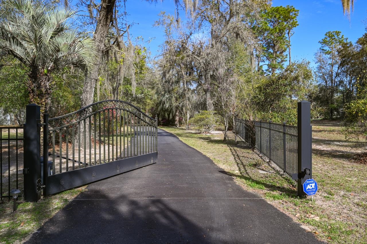 You found it, your very own Lake Front Home. A gated entry, with a flower lined drive welcomes you to Crystal Lake.  A Spring feed lake stocked for great fishing, with no public access. This property has 84ft of Sandy Beach Lake frontage. The house was built in 1950, a unique property, the walls are Brazilian Pecky Cedar, a full wall of cabinets built with reclaimed/refurbished barn wood and Gainesville Sun Press inserts. The Living room features a wood burning fireplace and fabulous Lake Views through the wall of sliding glass doors. The dining room will welcome a large family with plenty of seating. The kitchen has a large island, lots of other counter space and windows to enjoy the lake views. The windows add the option of passing food to outdoor dining. The screened Veranda is the perfect space to enjoy the relaxing serine moods inspired by this paradise. There is a spa room with access from the Veranda and  or 3rd bedroom.