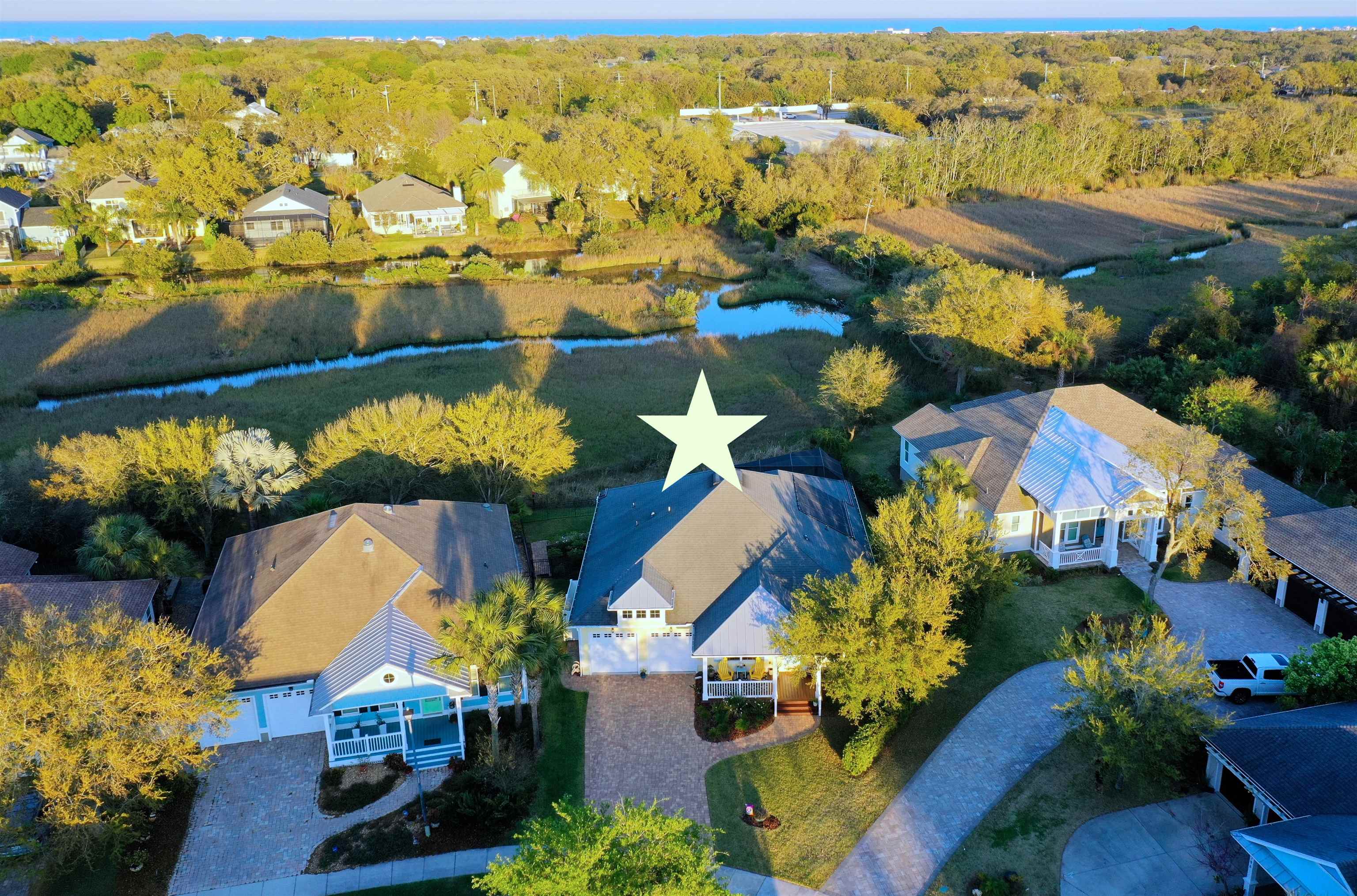 On the Island this cottage style home is on the marsh with a solar heated salt water and clear view screened pool! This perfect location is in SeaGrove, a coveted Anastasia Island neighborhood. 4bdr, 2ba, large kitchen/family room with gas fireplace leading to a glassed in sunroom and out to the pool and fenced yard that overlooks the marsh and tidal creek. This home has it all. In addition there is a separate dining room and a den/office with custom built-in shelving. The updated kitchen has a 7 1/2 x 5 1/2 ft island, double ovens, an induction cooktop, a brand new fridge, soft close cabinets with roll outs and a pantry. The primary bedroom with a shiplap accent wall is spacious and double walk-ins with custom wood shelving and custom window treatments are added features.The primary bath has a separate shower/tub and has been tastefully updated. The laundry includes washer/dryer, laundry sink, and built in shelves. Some additional features are a water softener, alarm system, outdoor