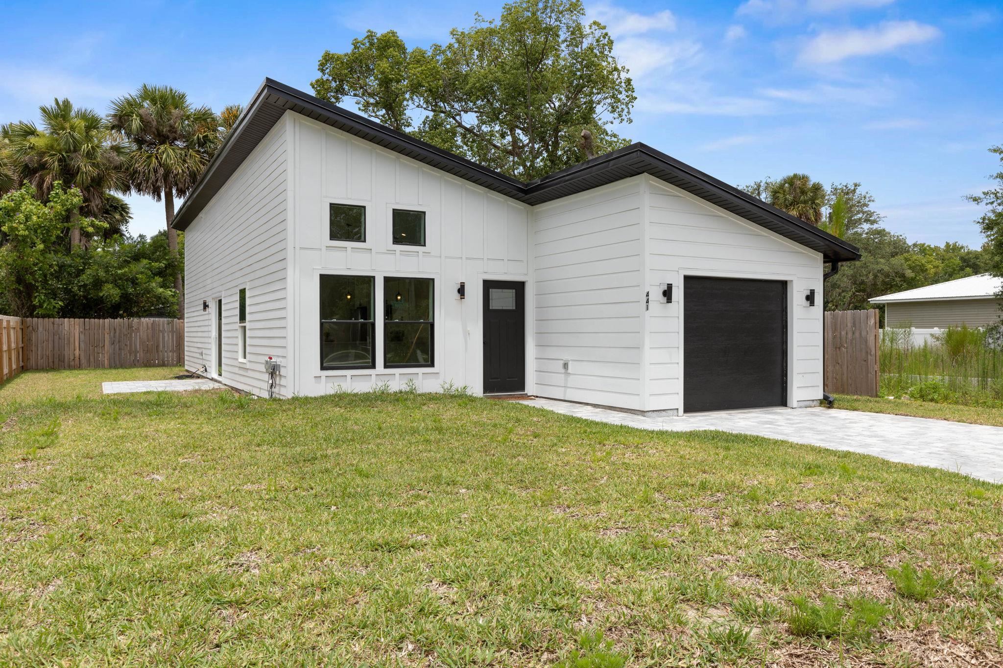 Some Photos have been virtually staged. Introducing 441 S Woodlawn St. A beautifully crafted new construction home (2024) nestled in the established Colee Subdivision of St. Augustine. This thoughtfully designed 3-bedroom, 3-bathroom residence features 1,180 square feet of modern living space, complete with stylish upgrades. Inside, you'll find an open concept layout with soaring vaulted ceilings and wood-look vinyl flooring throughout, creating a light and airy atmosphere. The sleek kitchen features quartz countertops, stainless steel appliances, and clean, modern finishes—perfect for both everyday living and entertaining. Sliding glass doors lead out to a paver patio and a  fenced backyard, ideal for outdoor relaxation or play. The primary suite offers a private retreat with a walk-in closet, step-in shower, and contemporary touches. The second bedroom features its own en-suite bathroom, making it perfect for guests or family members. The third bedroom can easily serve as an