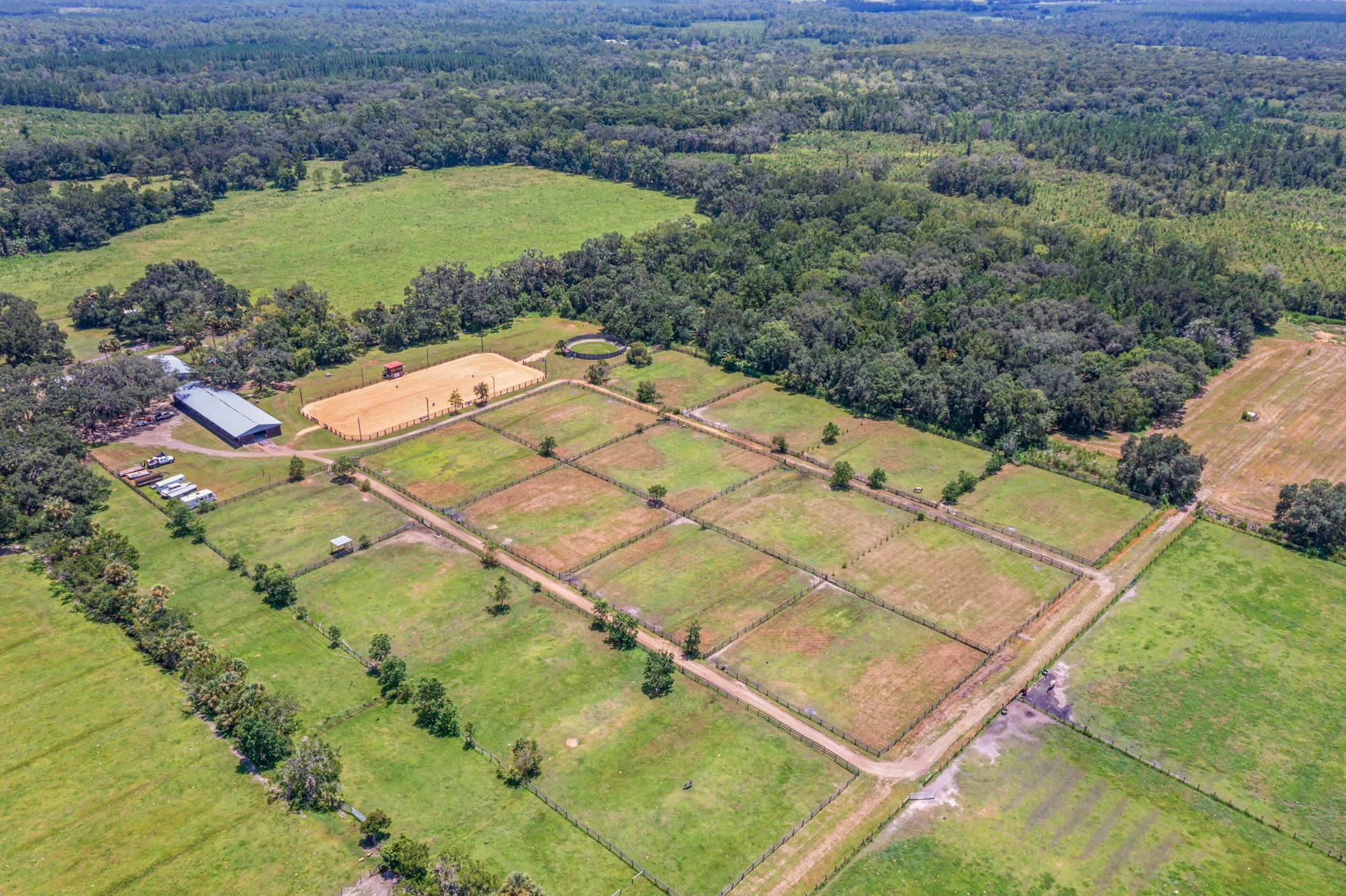 Welcome to Split Oak Farm — a distinguished 54-acre equestrian estate where world-class facilities meet the serenity of Florida's horse country. Perfectly positioned just one hour from the prestigious World Equestrian Center and only 30 minutes from the sandy shores for oceanfront riding, this property offers an unparalleled lifestyle for both professional competitors and passionate horse enthusiasts.   From the moment you arrive, you'll be captivated by the farm's thoughtful design and pristine presentation. A grand 150' × 250' lighted arena takes center stage, bordered by 29 oversized 12' × 14' stalls, 14 lush green pastures, a professional round pen, and peaceful riding trails that wind through the property. Covered wash racks, an air-conditioned tack room, and a welcoming lounge provide both comfort and efficiency, while safe fencing and manicured grounds reflect a commitment to excellence.   Currently operating as a thriving full-service boarding and training facility, Split