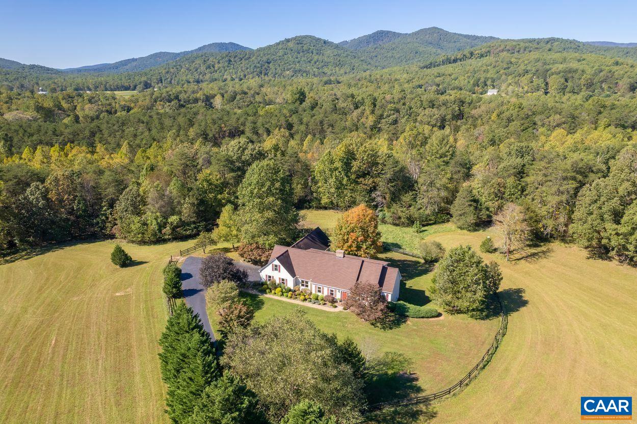 22 acre country retreat with great views of Buck Mountain in Farmington Hunt Country. Rural paradise, yet only 22 minutes to UVA and 15 to plentiful shopping and dining. Walk to Glass House Winery. Optimal functionality for horses and dogs with ten acres of fenced pasture plus stone dust riding ring. Two stall barn and luxurious indoor/outdoor dog kennels and wash station. Forest with stream and open fenced fields. Mature, cedar lined, paved driveway is a scenic drive to the large home with first and second floor master suites, massive living room with wet bar, and indoor/outdoor living spaces are fantastic for entertaining. Separate living quarters in the walk out basement with full kitchen and more. Self sufficient with whole house generator. You can't beat this Western Albemarle location.