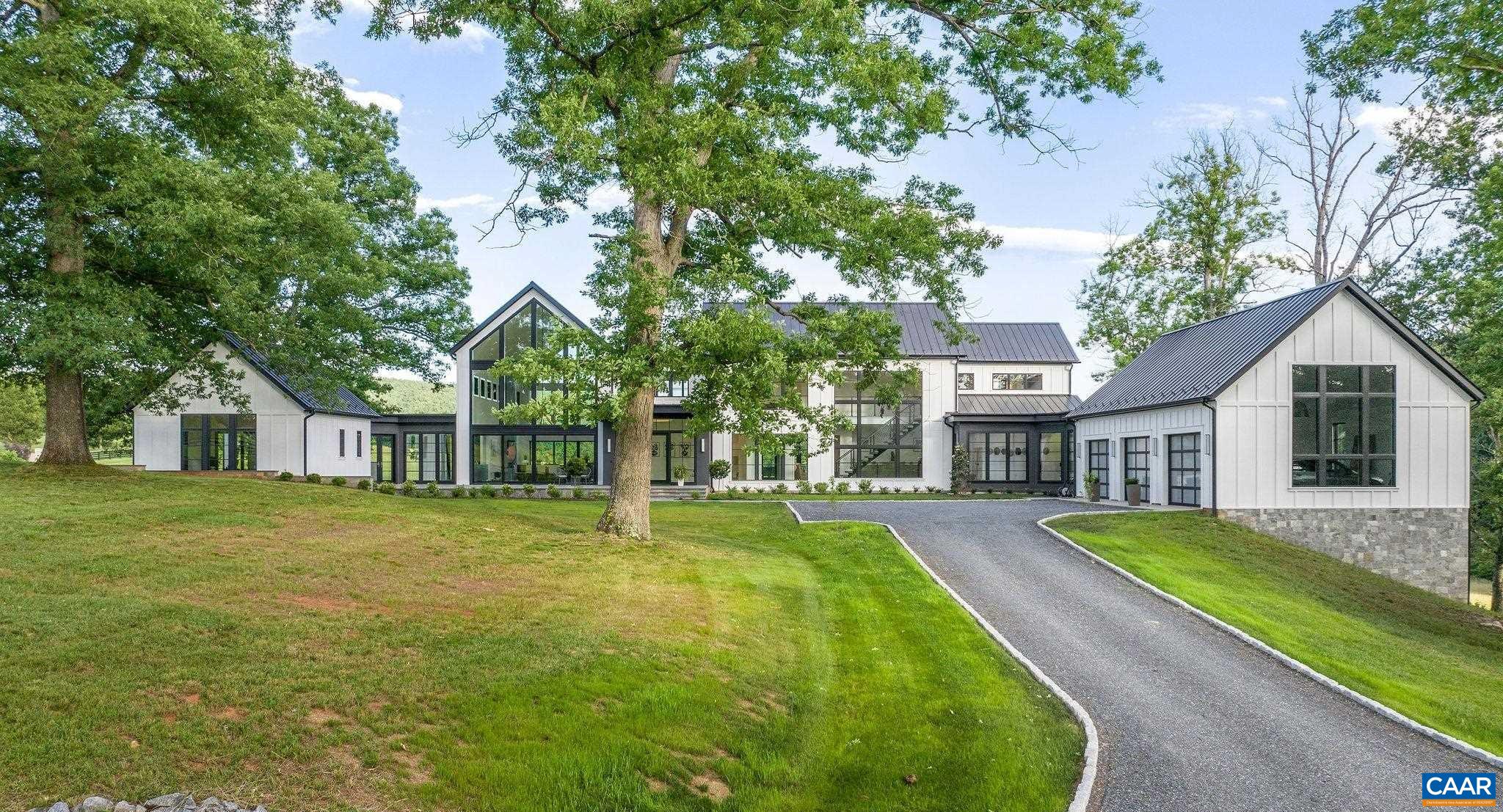Sited beautifully amongst massive oak trees, this dazzling home enjoys incredible views of rolling hills & the mountains beyond, to the front and rear of the residence. The centerpiece of the interiors is a great room that soars to 31 feet with walls of glass to take in the views. Other ceilings are 10-11ft.  Dramatic stone & tile selections throughout. 1st floor master plus an additional 1st fl bedroom suite that doubles as a home office. 3 bedroom suites up and guest suite in the basement. A large, covered rear porch is ideal for entertaining next to the horizon pool. Features incl' wide plank oak flooring on all 3 floors, geothermal HVAC, home gym, and butler's pantry. Comprised of two 21 acre parcels, one of which fronts on Red Hill Rd, the property enjoys 2 entrances & can be subdivided. Below the house is a large, multi-purpose barn with half bath, devoted septic. Horse friendly land! Lovely, bold creek traverses the property. 15 gallon per minute well.  Fiber optic internet. 12 minutes to town, Boar's Head, Farmington et al