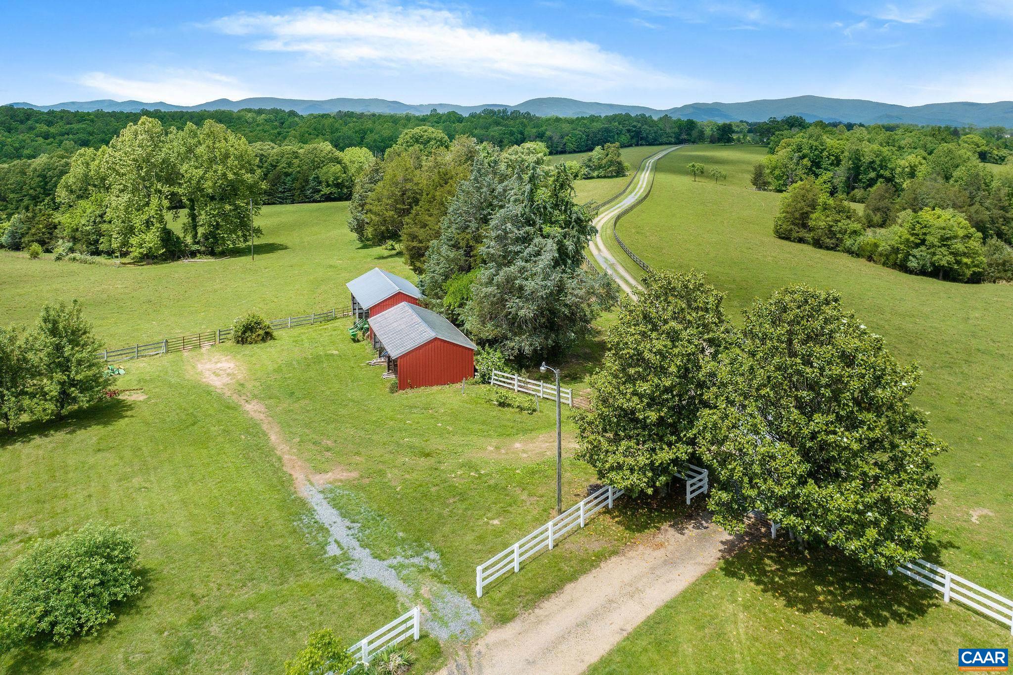 This beautiful 124 acre Albemarle farm with magnificent Blue Ridge and Southwest Mountain views, located just 10 min. from the Route 29 corridor and the C’ville airport, offers the ideal setting not only for those looking for convenient amenities, excellent vineyards, & all that Charlottesville has to offer,  but also those seeking easy access to DC, NY & other major cities. Comprised of approx. 50% open pasture encircled by privacy-enhancing hardwood forest, this stunning property is NOT IN CONSERVATION EASEMENT but does enjoy land use status for cattle. With several streams and springs, a large farm equipment building, storage shed, & fencing and cross fencing, it is well suited for horses, livestock, crops, and hay. Flanked by large estates and abutting Chris Greene Lake Park, the land is a tranquil haven for wildlife with lovely views of the farm’s open fields & gorgeous sunsets. This property also offers a charming 5 bedroom, 3.5 bath Cape style home w/main level primary, whole house generator, 2 car garage, & light-filled, spacious rooms. A great opportunity to create a family compound or live in the current home while creating a new estate on one of the several outstanding building sites.  5 theoretical division rights.