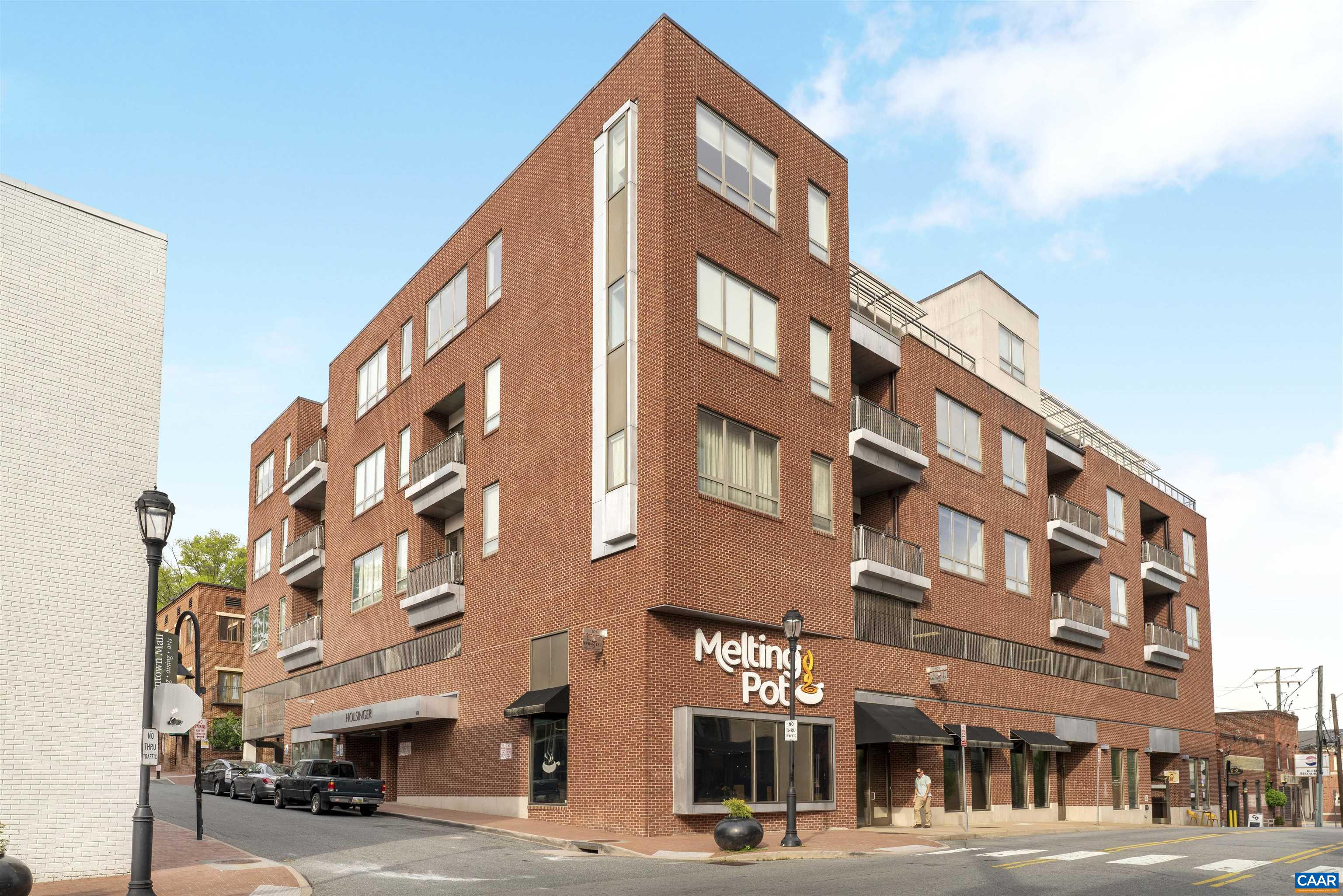 This exceptional 2 bedroom, 2.5 bath condo is ultra-conveniently located just a few steps from the bricks of the historic Downtown Mall of Charlottesville in The Holsinger building! This unit enjoys the best of Downtown living with easy access to all of downtown's great amenities. An inviting floor plan with 1,891 finished square feet of living space featuring spacious living & dining room, fully equipped kitchen with stainless steel appliances and granite countertops, hardwood floors, huge windows with abundant natural light. Private balcony has gorgeous views of nearby Southwest Mountains. Primary bedroom has bath with dual vanities, walk-in shower and walk-in closet, and the second bedroom is en-suite. Private, secure and covered garage parking, and extra storage unit in the building. Outstanding opportunity to live on the Downtown Mall and soak in the best of city life!