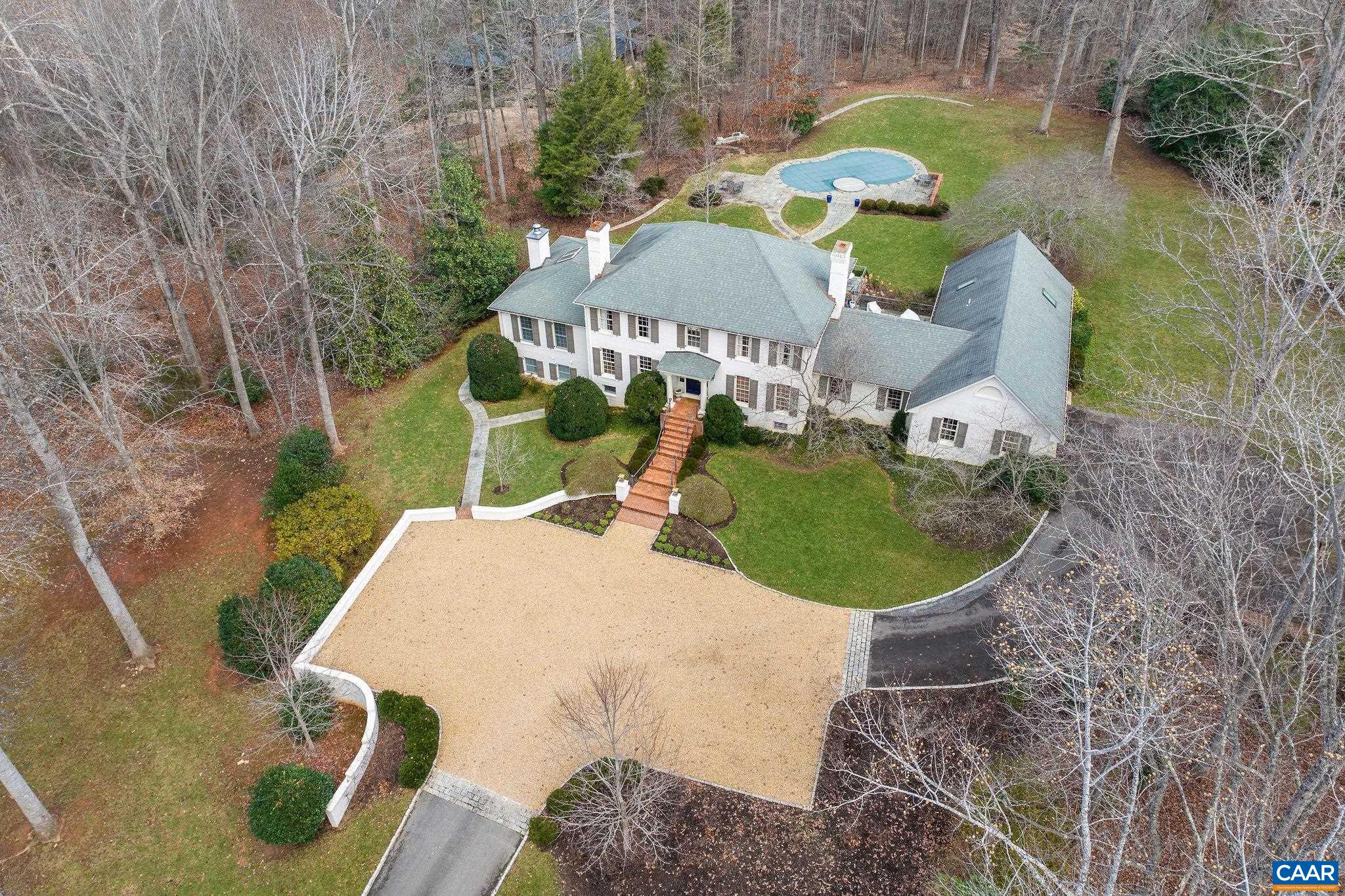 Set privately within moments of Farmington and minutes to UVA and Downtown, this classic, all brick Georgian sits on 3 lovely acres of mature landscaping complete with pool and hot tub. The floor plan provides a 1st floor primary as well as a 2nd floor primary. Recent renovations and additions provide dramatic living and entertaining spaces.  The centerpiece of the home is the recently added great room with soaring ceilings, endless windows and french door access to bluestone terraces.  On the terrace level, in addition to a family room with fireplace, there is a a bed, bath with sauna, and efficiency kitchen with its own entrance, all added in the last 10 years. The entire rear elevation of the house offers expansive bluestone terraces accessed via the great room, kitchen, and family room for wonderful flow btw interiors and the lovely outdoor living spaces.  Furnishings available. Zero road exposure.