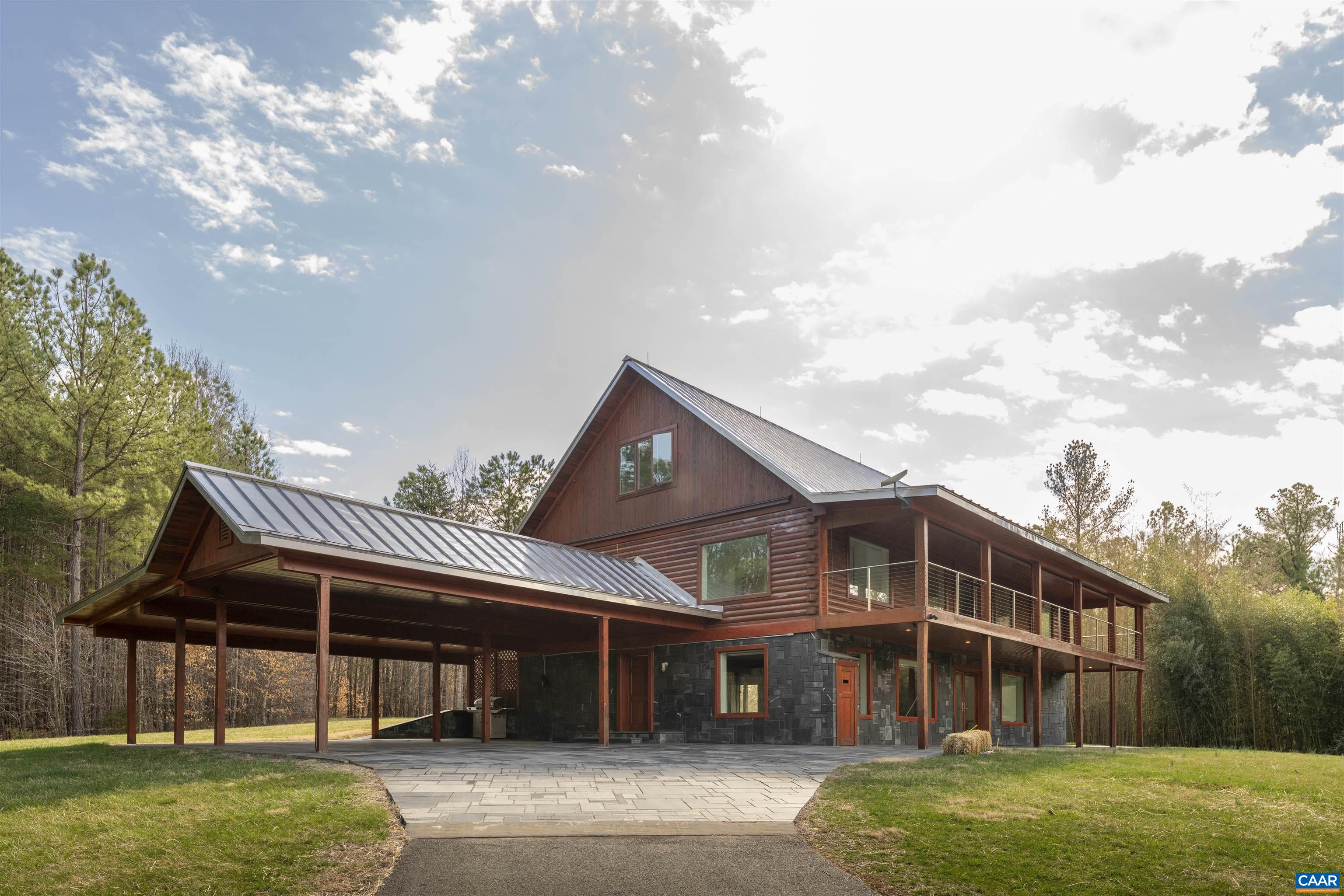Privately set on 5.5 acres in northern Nelson Co., the rustic log and soapstone exterior belies a visually stunning sleek and sophisticated modern interior full of unusual and high-quality features, systems, and finishes. 3 bedrooms and over 4000sf of finished living. Oversized windows let natural light pour into the space.  Highly durable Terrazo and soapstone flooring, built in custom cabinetry everywhere you turn, high-tech lighting and electrical, geothermal HVAC, standing seam steel roof, retractable blinds and porch screens, security and sprinkler system, whole house generator, level 2 EV charger, whole house lightning protection, advanced regenerative water filtration, soundproofed fridge, and much more.  Front and rear porches allow for expansive views of local mountains and forests.  Paved drive, gated entrance, cisterns for water storage, shed with electric, extreme privacy, and 200ft of creek frontage.  The essence of a retreat, with no sacrifices for modern amenities or connectivity.  High-speed Starlink internet.  You could not come close to replicating this property for this price.