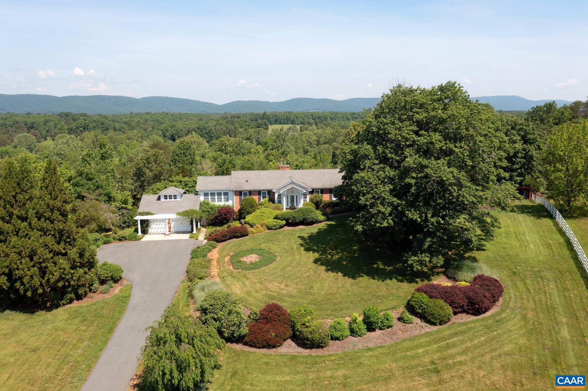 KESWICK - Comfortable and spacious residence privately sited on ten acres with views of the Southwest Mountains. The light and bright main level features living room, chefs kitchen with dining area, family room, full bath, primary suite and bath with adjacent library/home office. The lower level has large family/bonus room, four bedrooms, two full baths, laundry room along with storage room.  Adjacent two car garage. Great outdoor spaces on both levels. Mature landscaping and gardens. Fenced pasture and run-in shed suitable for horses. Fiber Optic Internet.  Convenient to heart of Keswick or to Charlottesville and University of Virginia from 250 East or I 64 East to Richmond area.