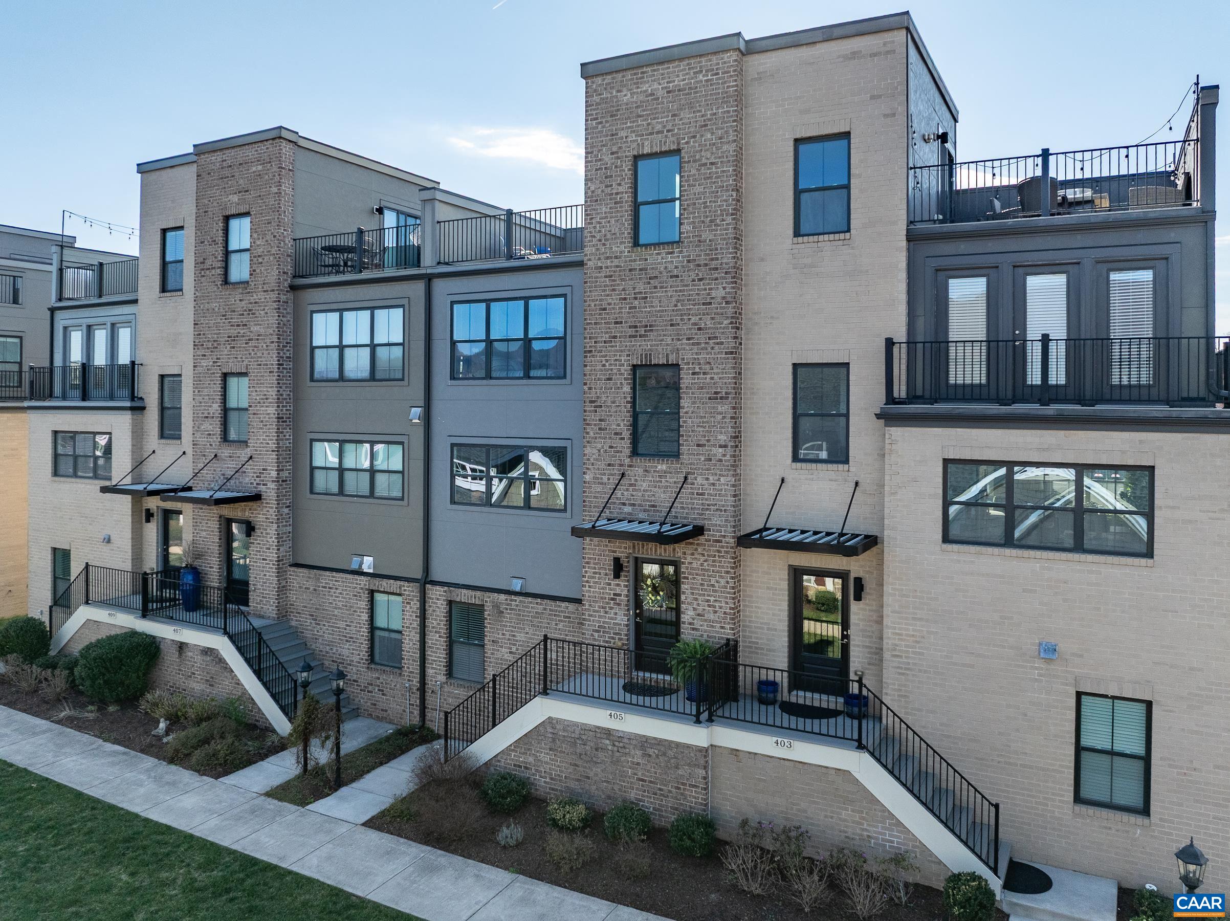 Discover an extraordinary living experience in Old Trail, where this stunning four-story, townhome on green space combines modern design with breathtaking mountain vistas walkable to the Town Center. Step inside to an inviting, light-filled interior featuring espresso colored hardwood floors. The stairwells have been opened, creating a sense of spaciousness and elegance. The heart of the home is an open-concept living area with a gourmet kitchen that boasts modern gray cabinetry, luxurious granite countertops, tile backsplash, and functional island. The home's thoughtful layout maximizes both comfort and functionality. The bedroom level showcases a generously sized owner's suite with walk-in closet and a spa-inspired bathroom, featuring a sleek frameless glass shower. Two additional bedrooms provide ample space for family or guests. The ground floor offers versatility with a fourth bedroom/home office/home gym with upgraded carpet. Perhaps the true gem of this property is the spectacular rooftop terrace—an urban oasis with panoramic mountain views that will become your favorite retreat. Practicality meets luxury with a two-car garage and a convenient rear deck for outdoor dining and grilling Don't miss out!