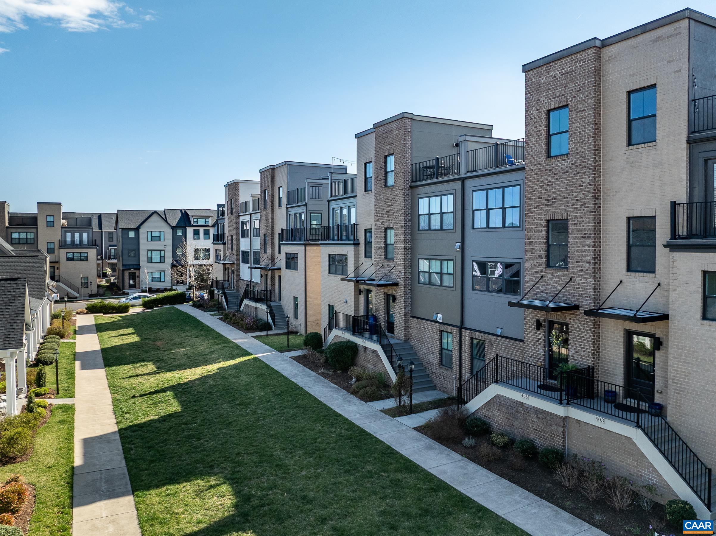 The views!!  Amazing!  Discover an extraordinary living experience in Old Trail, where this stunning four-story, townhome on green space combines modern design with breathtaking mountain vistas walkable to the Town Center. Step inside to an inviting, light-filled interior featuring espresso colored hardwood floors. The stairwells have been opened, creating a sense of spaciousness and elegance. The heart of the home is an open-concept living area with a gourmet kitchen that boasts modern gray cabinetry, luxurious granite countertops, tile backsplash, and functional island. The home's thoughtful layout maximizes both comfort and functionality. The bedroom level showcases a generously sized owner's suite with walk-in closet and a spa-inspired bathroom, featuring a sleek frameless glass shower. Two additional bedrooms provide ample space for family or guests. The ground floor offers versatility with a fourth bedroom/home office/home gym with upgraded carpet. Perhaps the true gem of this property is the spectacular rooftop terrace—an urban oasis with panoramic mountain views that will become your favorite retreat. Practicality meets luxury with a two-car garage and a convenient rear deck for outdoor dining and grilling Don't miss out!