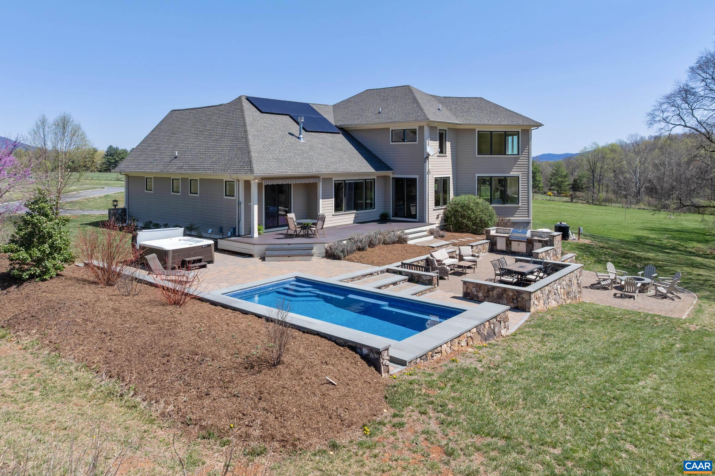 Nestled against the Blue Ridge, this distinctive Afton estate will amaze with spectacular 360 degree views! A true Net Zero property, including handsome main residence, guest cottage, barn and small vineyard. A flagstone porch welcomes you home! Open floor plan, hardwoods and exquisite finishes. Main level Owner’s Suite w/ lavish bath, gorgeous LR w/ soaring stone fireplace & captivating views of mountain & woodlands. A stunning chef’s kitchen opens to dining nook and cozy family room flanked by windows. Gleaming granite island, Thermidor range and coffee/wine bar. An outdoor retreat awaits! Heated salt pool & hot tub, dining area, outdoor kitchen & firepit, framed by breathtaking stone & babbling stream. Upper level has two bedrooms sharing a hall bath, home office and large bonus space, all with incredible views! Comfy theater/game room downstairs which opens to fabulous wine cellar, perfectly chilled for 500 bottles of wine. Huge barn w/ patio and, to top it off, there’s a detached studio cottage w/ kitchen and bath, ready for guests or vacationers! Cottage patio overlooks mountains and vineyard, perfect for crafting small batch wine. All this & located in the heart of popular Nelson151 wineries, breweries, nearby AT and more!
