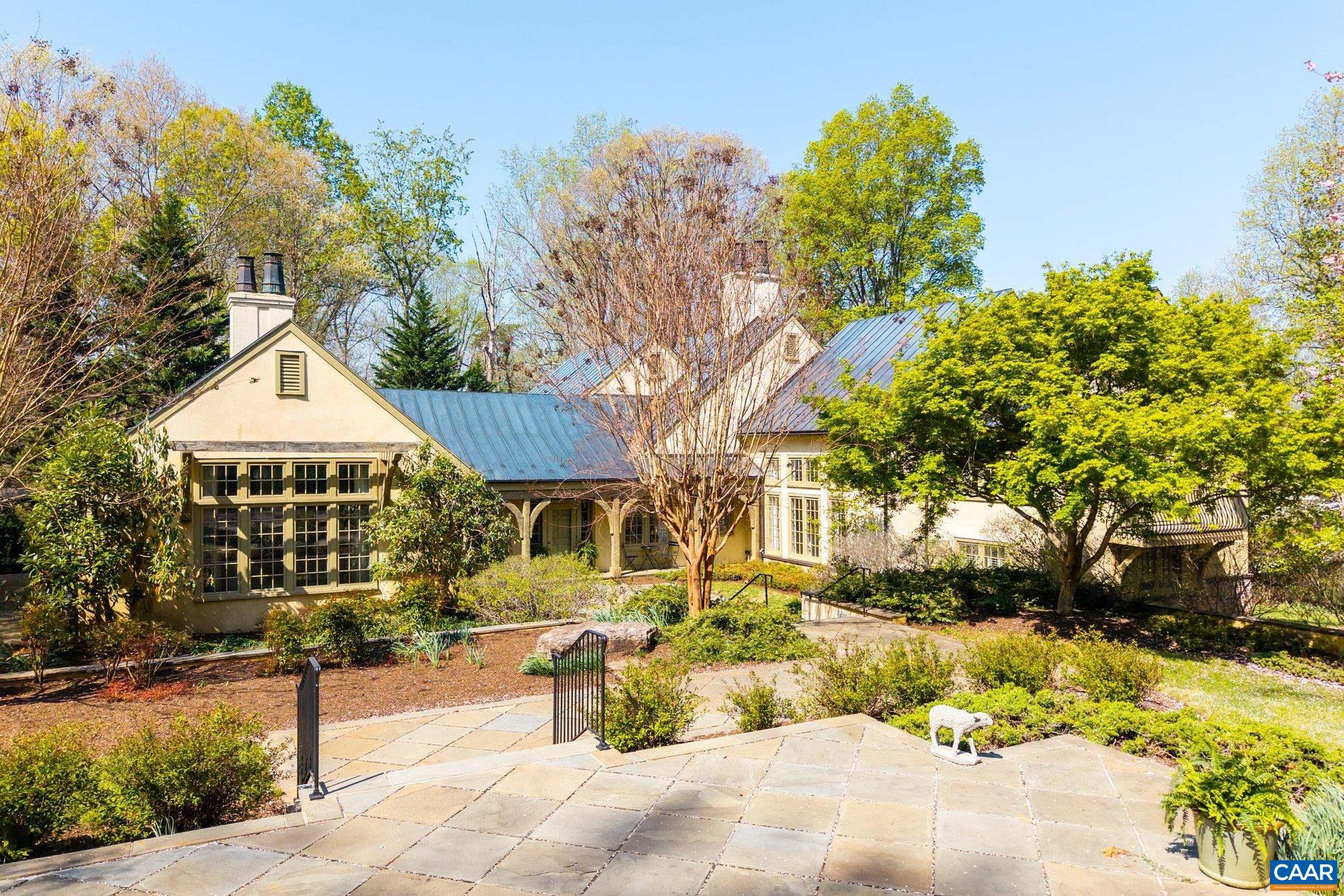 Tucked away on a serene, secluded 9-acre parcel, this breathtaking French Country home offers the perfect blend of refined living and pastoral charm—just 3 miles from town. Step inside to soaring vaulted ceilings adorned with hand-hewn beams, anchoring the spacious living and dining rooms—each centered around its own cozy fireplace. The gourmet kitchen is a chef’s dream, featuring a large central island, custom cabinetry, and a dedicated wine cellar for effortless entertaining. With 6 bedrooms and 6.5 baths spread across four thoughtfully designed levels, each private suite offers its own inviting sitting area, creating intimate retreats throughout the home. Outside, the meticulously crafted stone terraces and pergola set the stage for unforgettable summer evenings. A detached guest suite or office—with a full bath—adds flexibility for work or extended stays. Expertly constructed with the best materials including a copper roof and an energy-efficient Geothermal HVAC system, this home embodies quality, comfort, and elegance at every turn. An exceptional offering in one of Western Albemarle County’s most prestigious and sought-after locations.