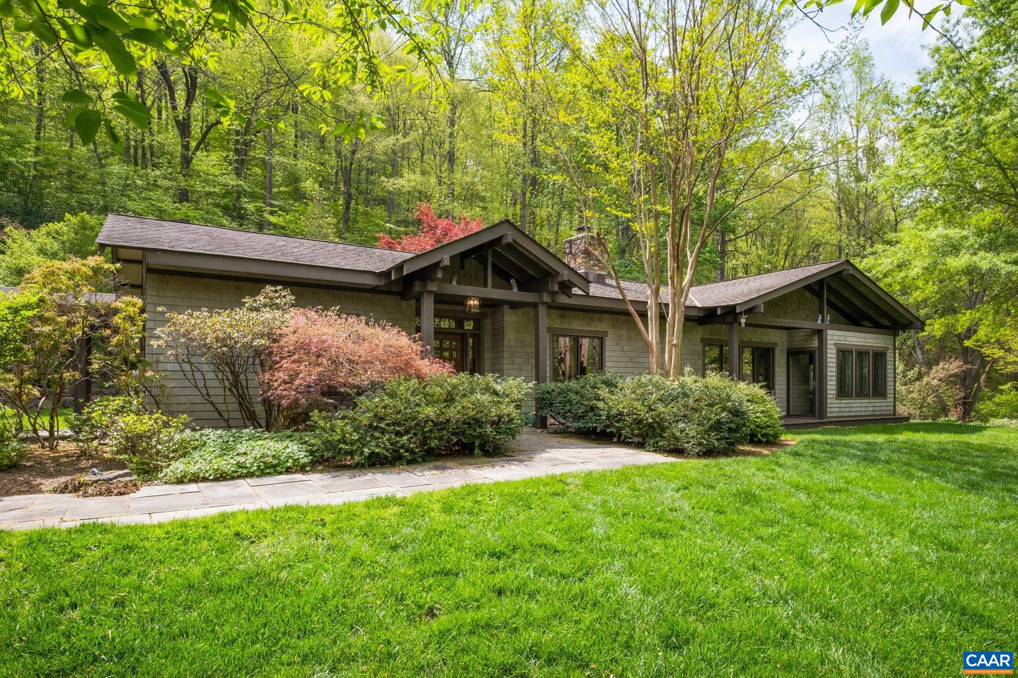 A private oasis that embraces you from the first moment you enter the property. The winding drive allows you glimpses of the pond and a meandering Taylor Creek as you make your way up the hillside to the custom built arts & crafts style home. Warmth and character meet you at every turn. No detail was overlooked on both the interior and exterior. Bask in water, mountain and garden views from any one of the outdoor living spaces - secluded terraced courtyard with handsome stone walls & walkways, covered patio and heated sunroom. Lovely perennial gardens provide beautiful blooms and color year round. Quality craftsmanship is recognizable throughout the one-level home. Many extras: floor to ceiling stone fireplace, hardwood floors, custom cabinetry & built-ins, high efficiency geothermal heating/cooling, FIBER internet, fenced garden, barn, and much more! Conveniently located within 5 miles of the amenities along 151 wine & brew trail, and only 25 mins to Charlottesville via 29.
