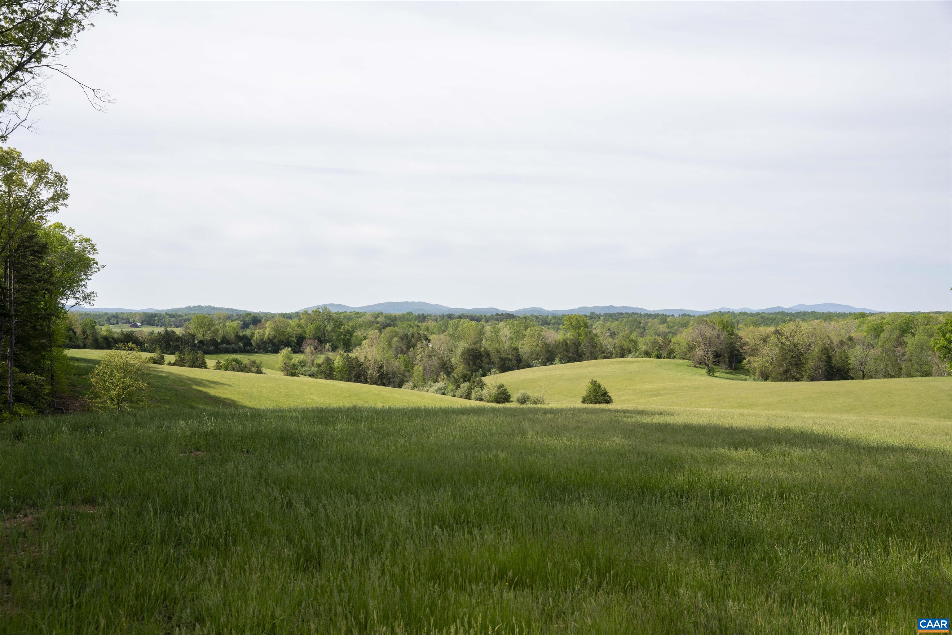 A breathtakingly beautiful 98 acres (2 parcels) with long dramatic views of both the Blue Ridge  and SW Mountains in a rural, protected area, minutes from town. No houses can be seen in the 180 degree main viewshed.  The rolling 92 acre parcel is a good mix of productive pasture and hardwoods with a spring-fed pond.  A thoroughly renovated three bedroom cottage and new, oversized garage are ready for occupancy or build your dream home on a level, elevated building site that both takes in the dramatic views and offers privacy. 92 acre parcel is protected by a conservation easement.  Includes an additional 5-acre, estate-caliber parcel with incredible views, not under easement.