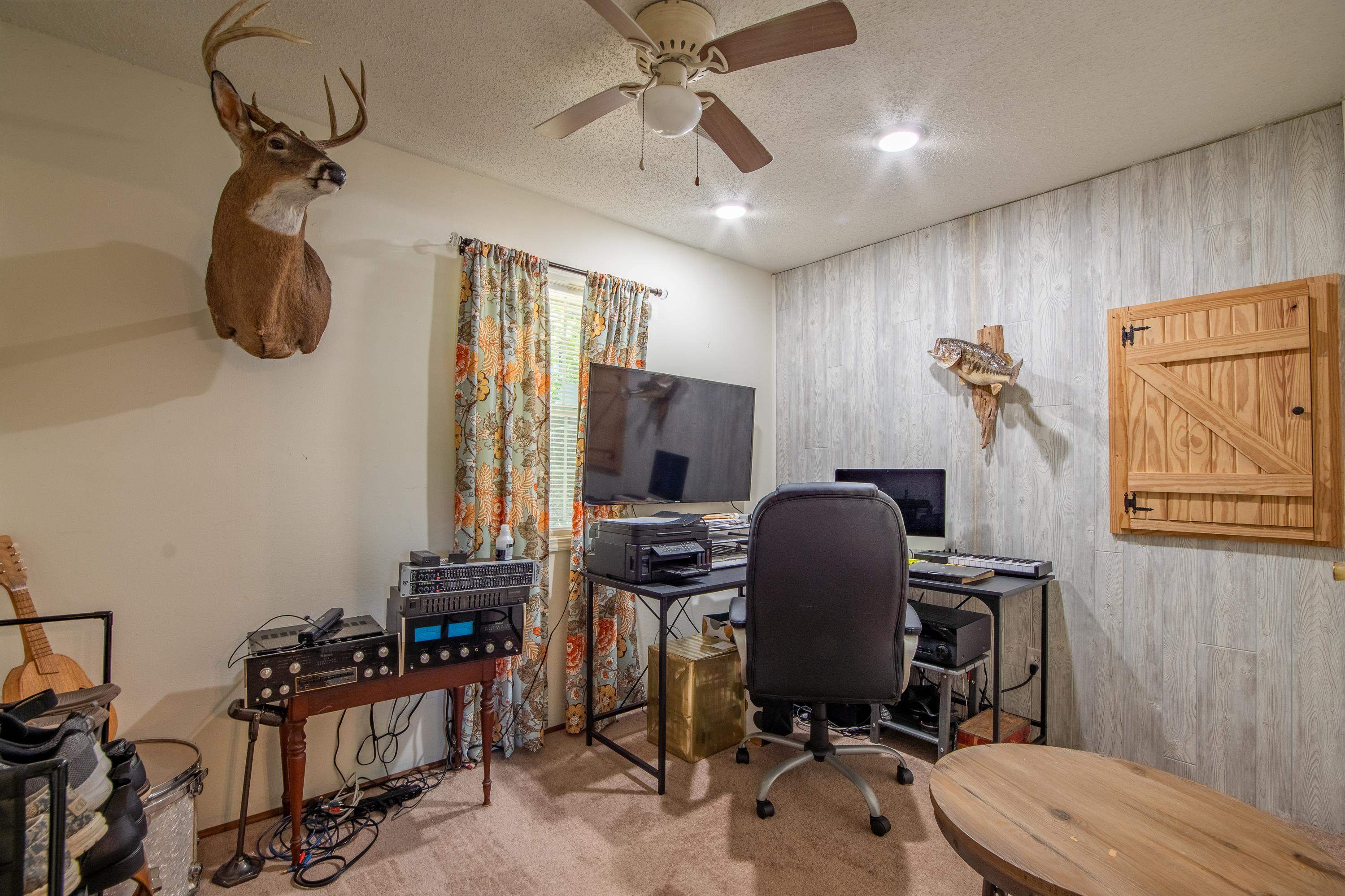 Carpeted bedroom with a textured ceiling and ceiling fan