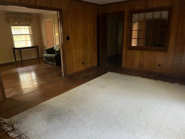 Empty room featuring wood walls and dark hardwood / wood-style flooring