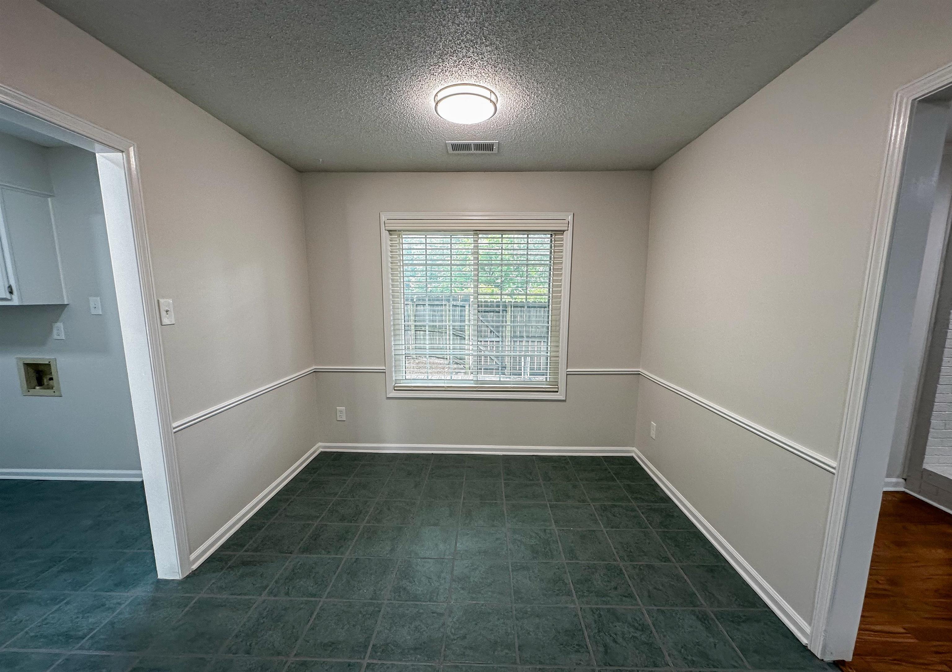 Eat in kitchen area featuring a textured ceiling and dark tile floors