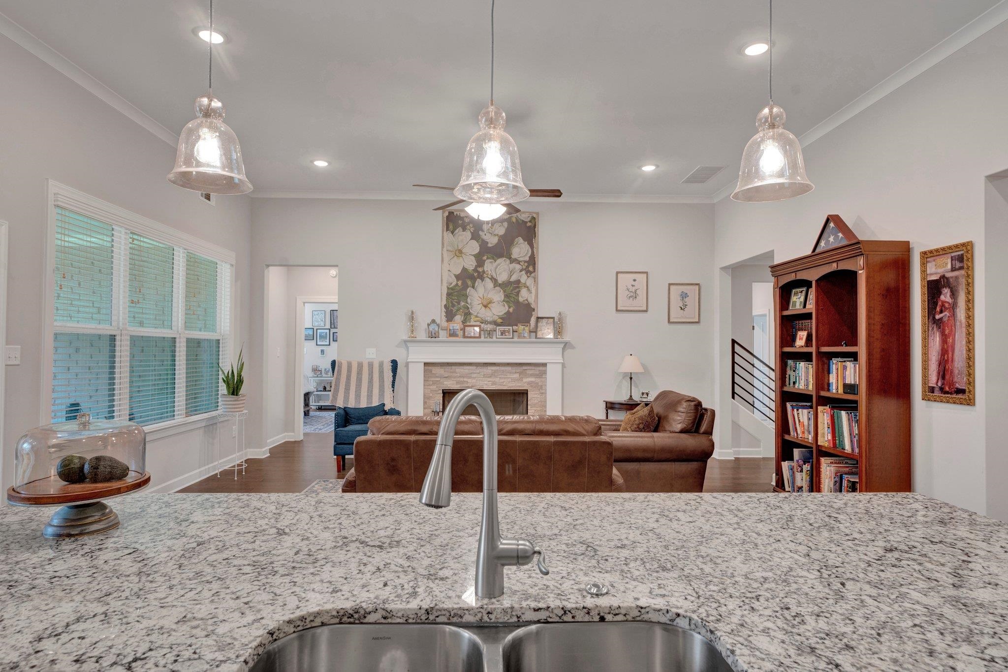 Kitchen featuring hardwood / wood-style flooring, ornamental molding, ceiling fan, and pendant lighting