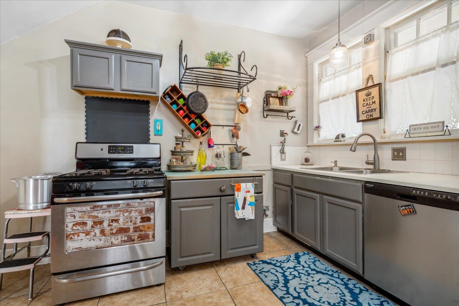 Kitchen with appliances with stainless steel finishes, sink, backsplash, and gray cabinets