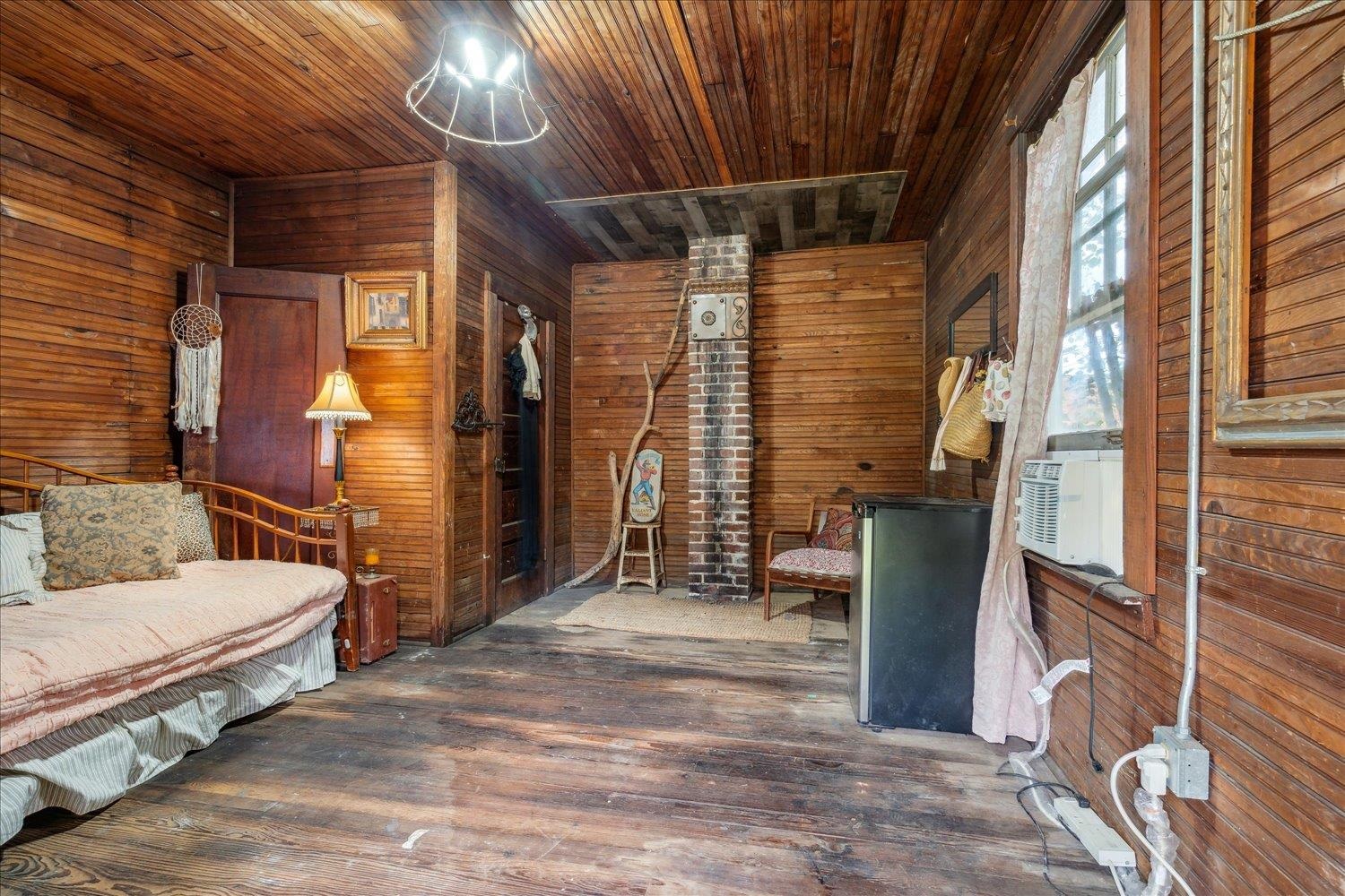 Interior space with wood walls, wood ceiling, and dark wood-type flooring