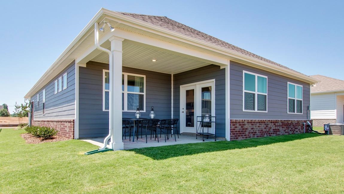 Rear view of house with a yard and a patio