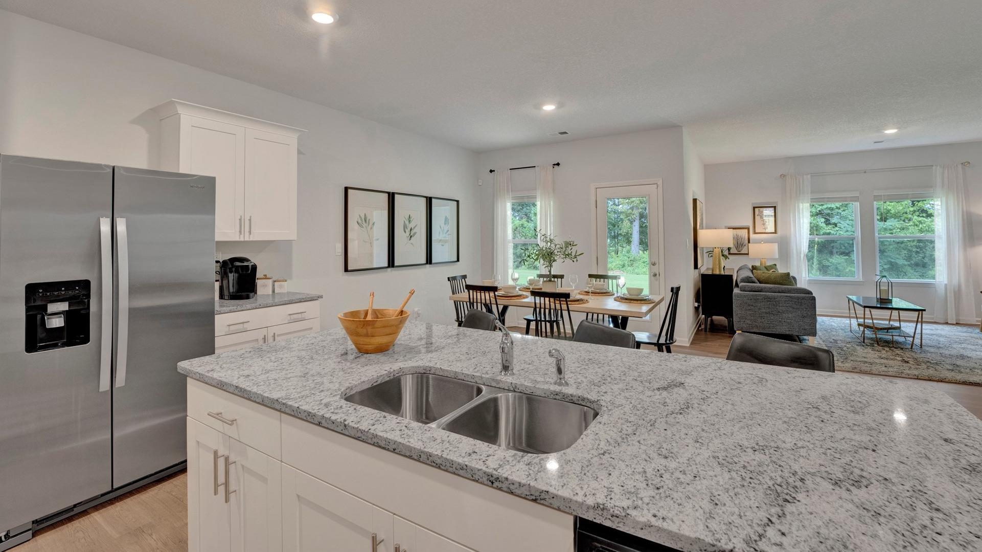 Kitchen featuring stainless steel refrigerator with ice dispenser, sink, plenty of natural light, and light hardwood / wood-style floors