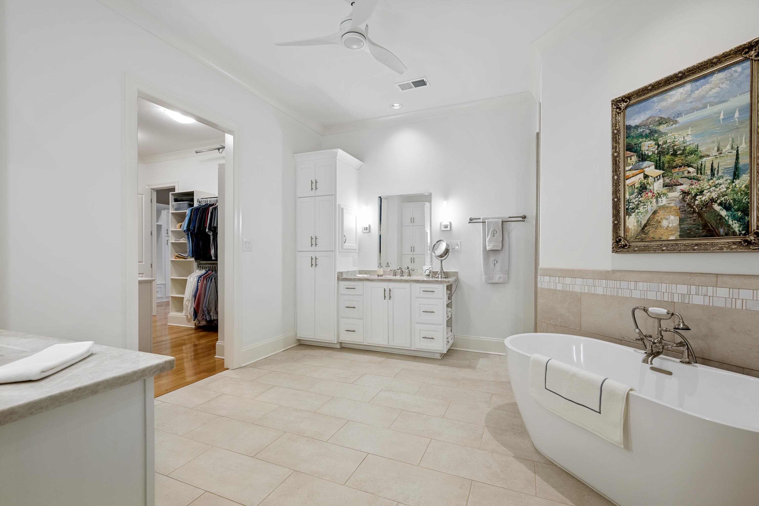 Bathroom featuring tile flooring, ornamental molding, ceiling fan, a bathing tub, and vanity