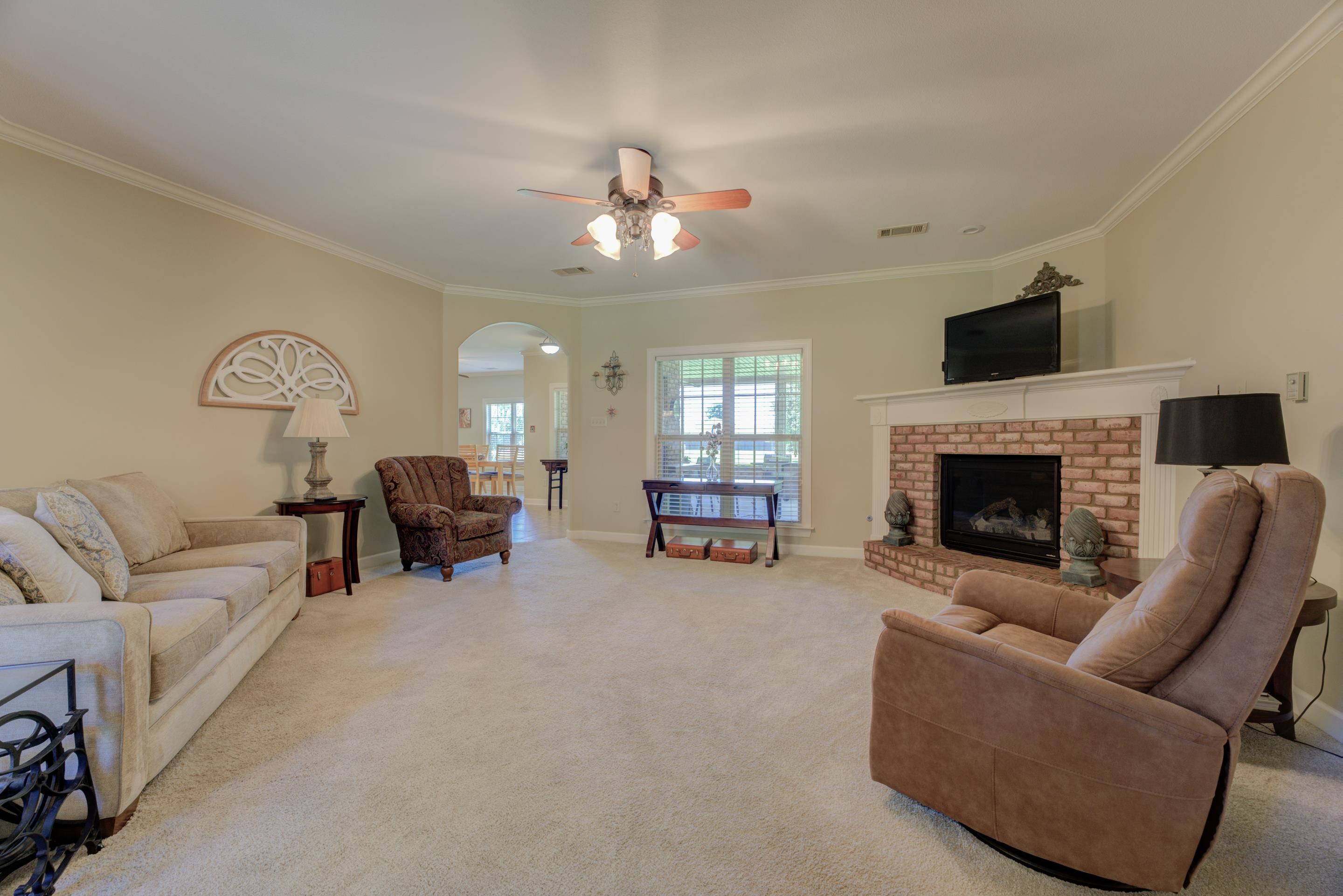 Living room with ceiling fan, Lots of ornamental molding, and a gas fireplace