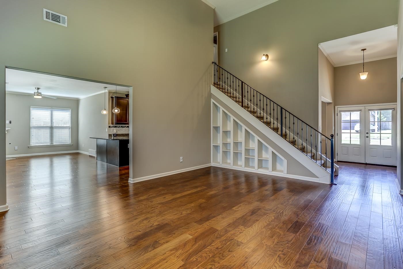 Living room featuring french doors, ornamental molding, hardwood / wood-style floors, a high ceiling, and ceiling fan