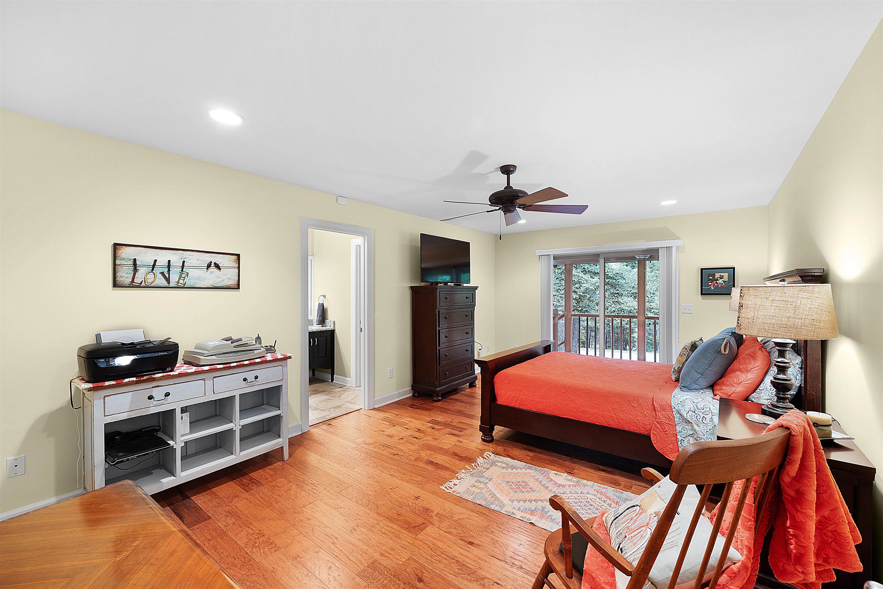 Bedroom with ceiling fan, hardwood / wood-style flooring, ensuite bathroom, and access to exterior