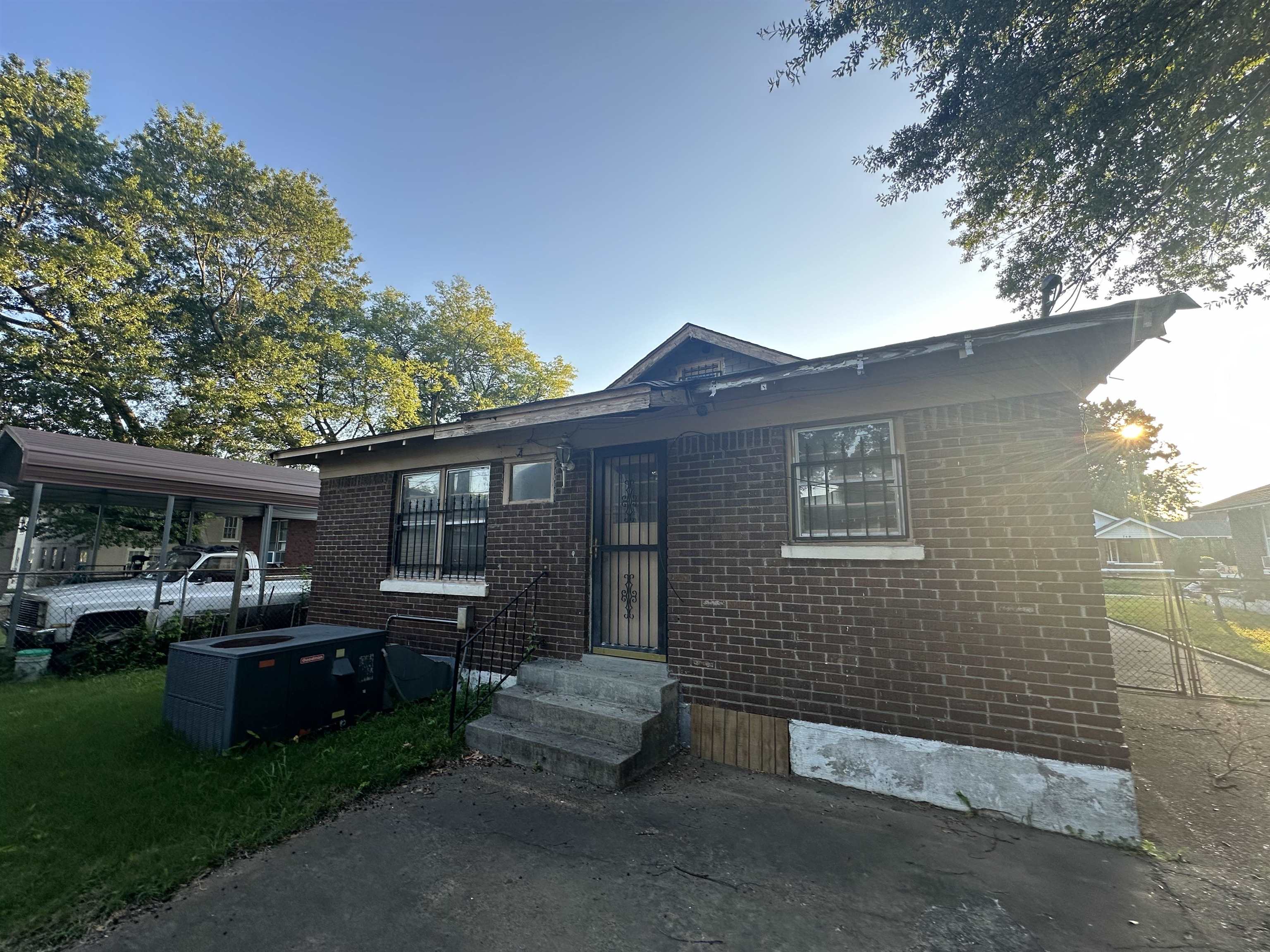 View of front of property with a carport and central AC
