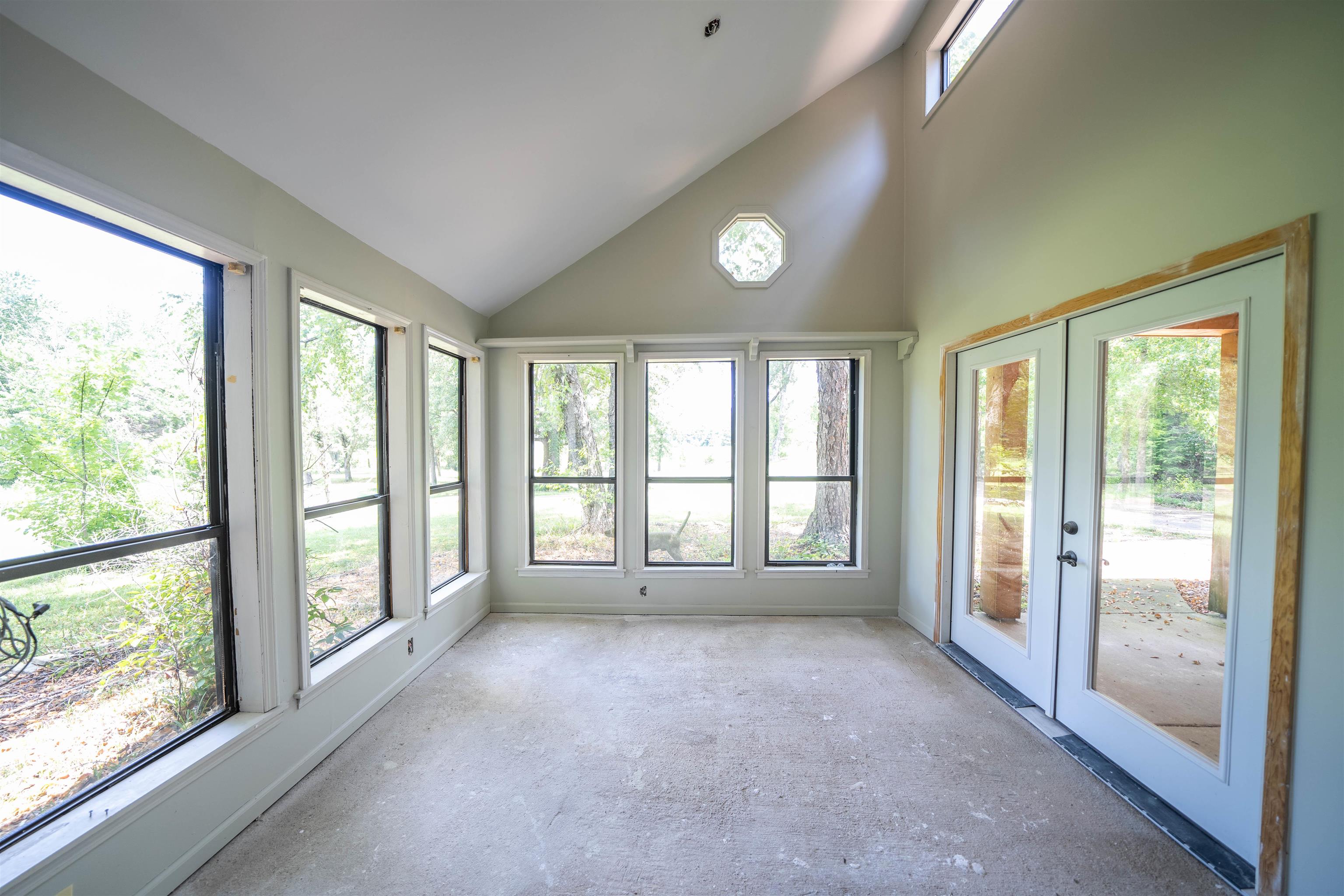 Unfurnished sunroom with vaulted ceiling and french doors