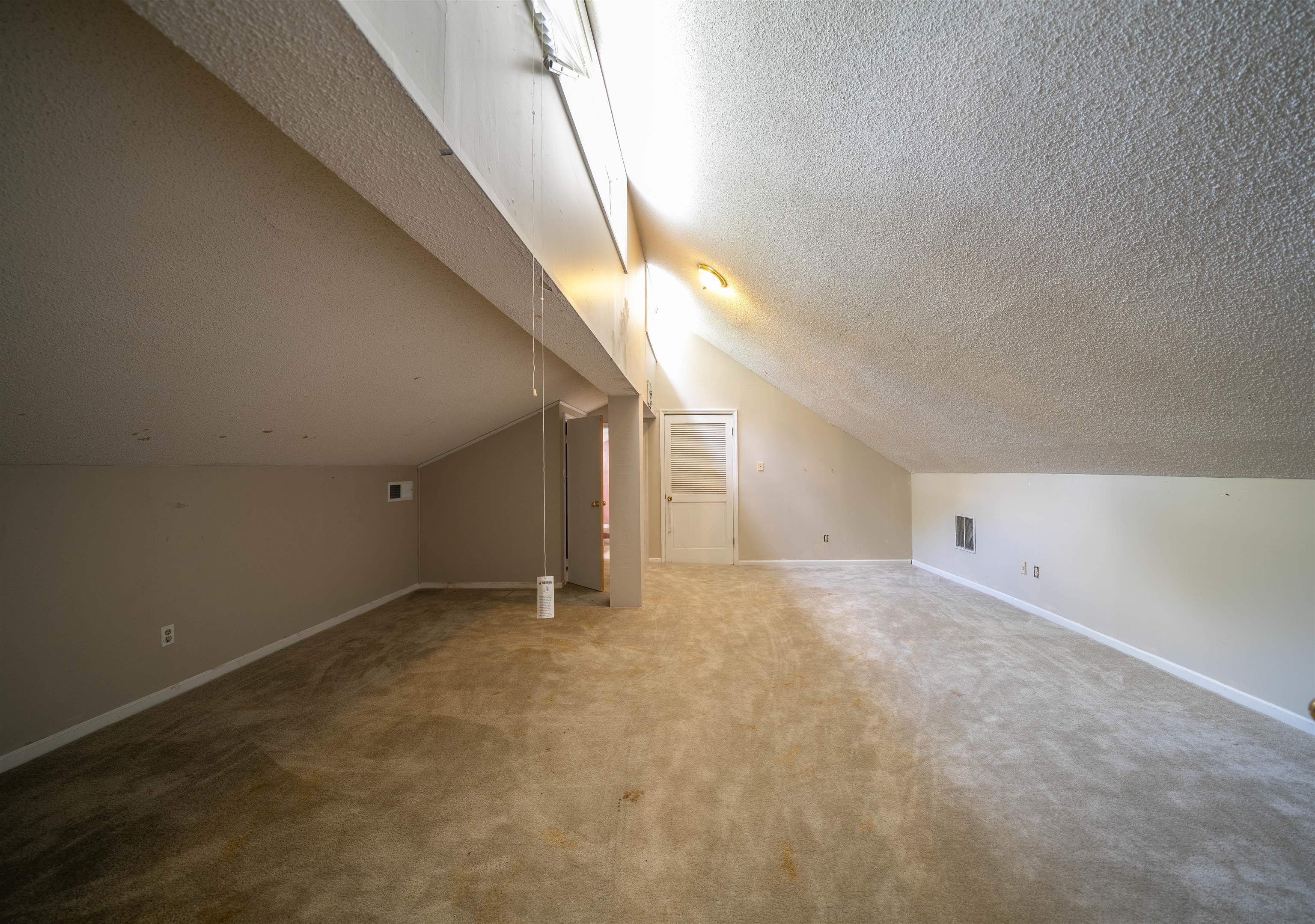 Bonus room with a textured ceiling, carpet floors, and lofted ceiling