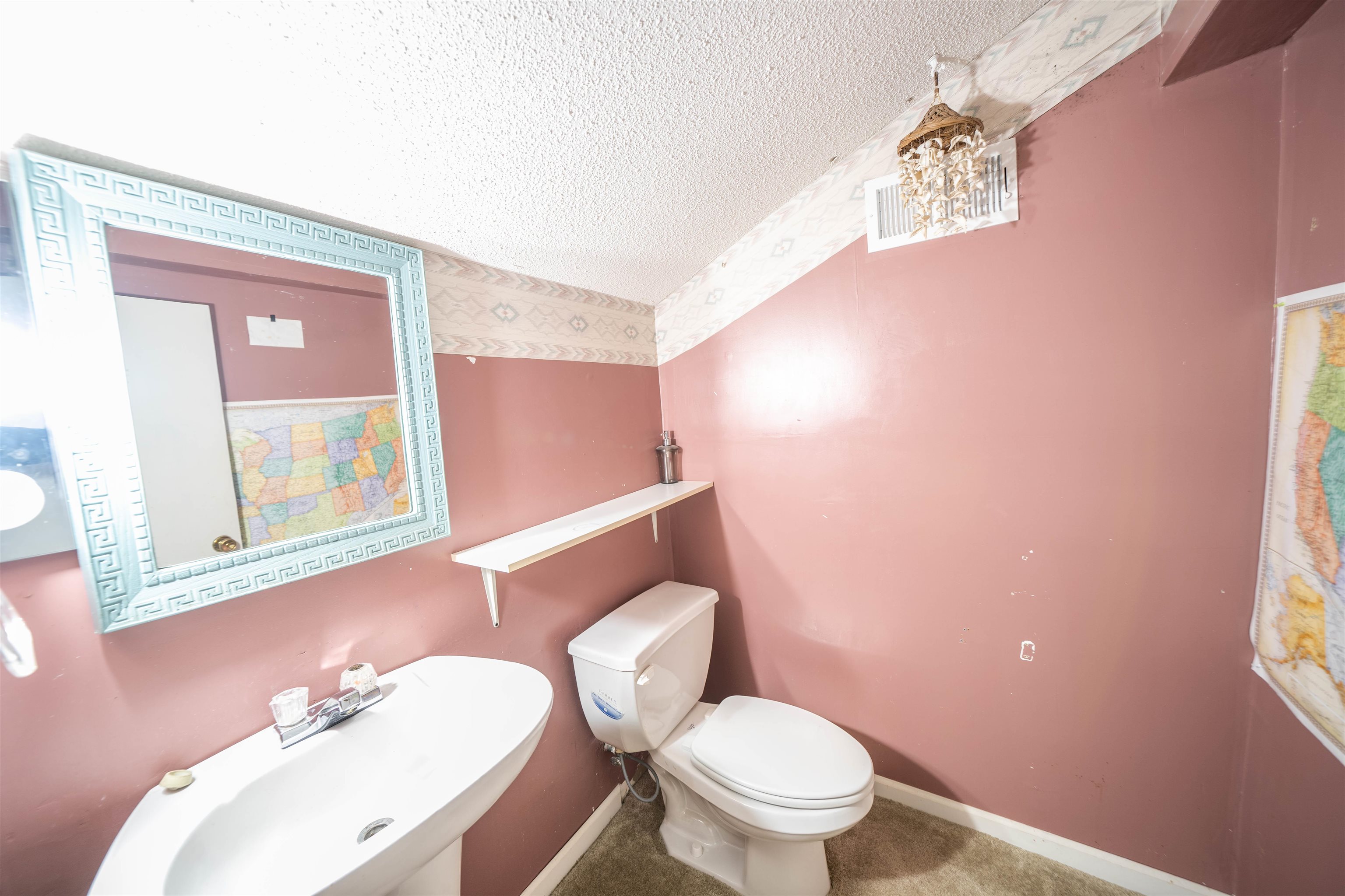 Bathroom with sink, a textured ceiling, and toilet