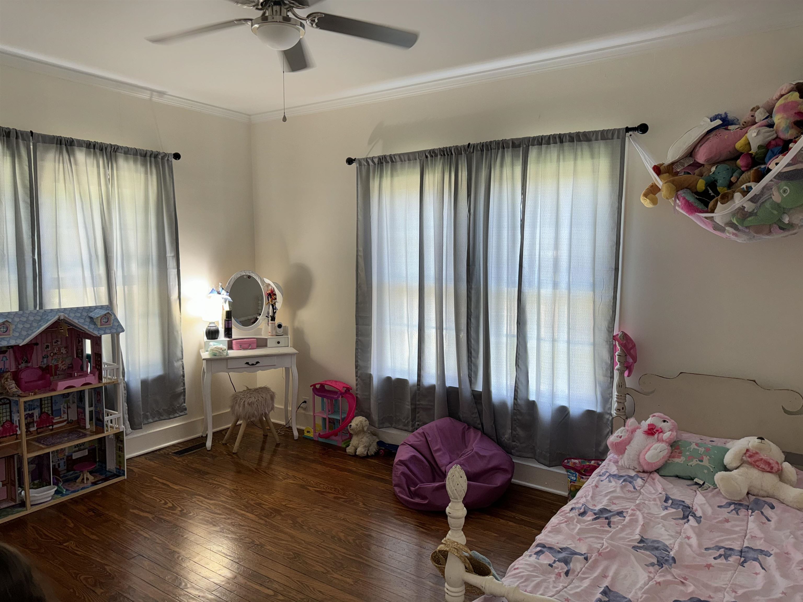 Bedroom with ornamental molding, dark hardwood / wood-style floors, and ceiling fan