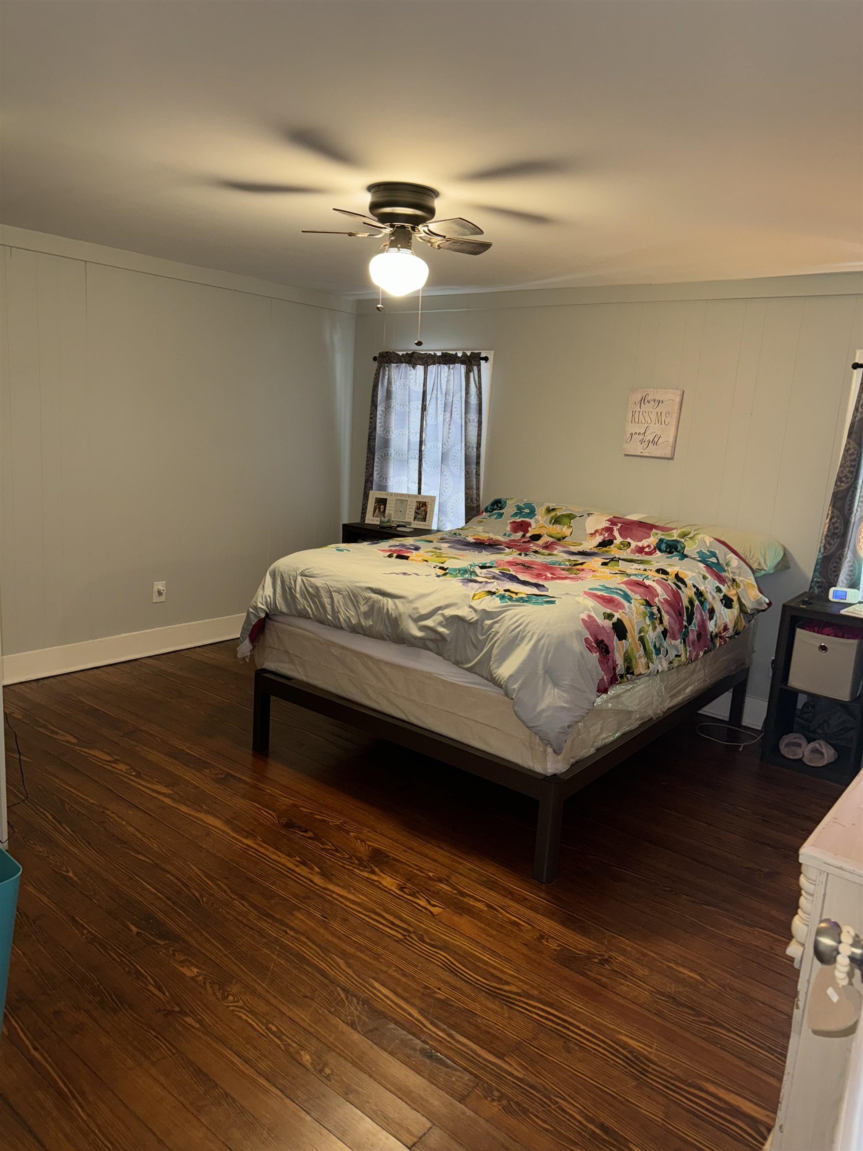 Bedroom with dark hardwood / wood-style flooring, ornamental molding, and ceiling fan