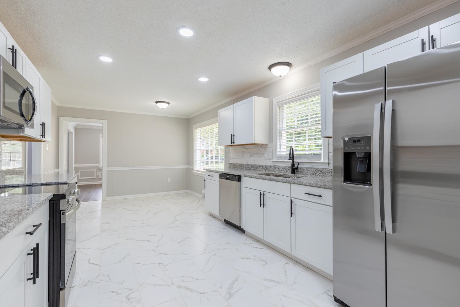 Sunroom with light tile floors and brick wall