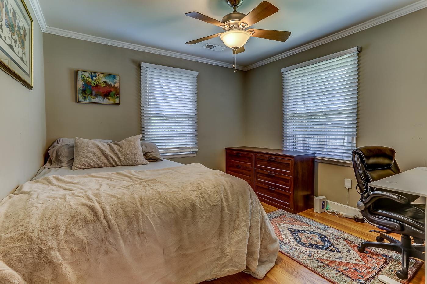 Bedroom featuring hardwood, ornamental molding, ceiling fan, and multiple windows