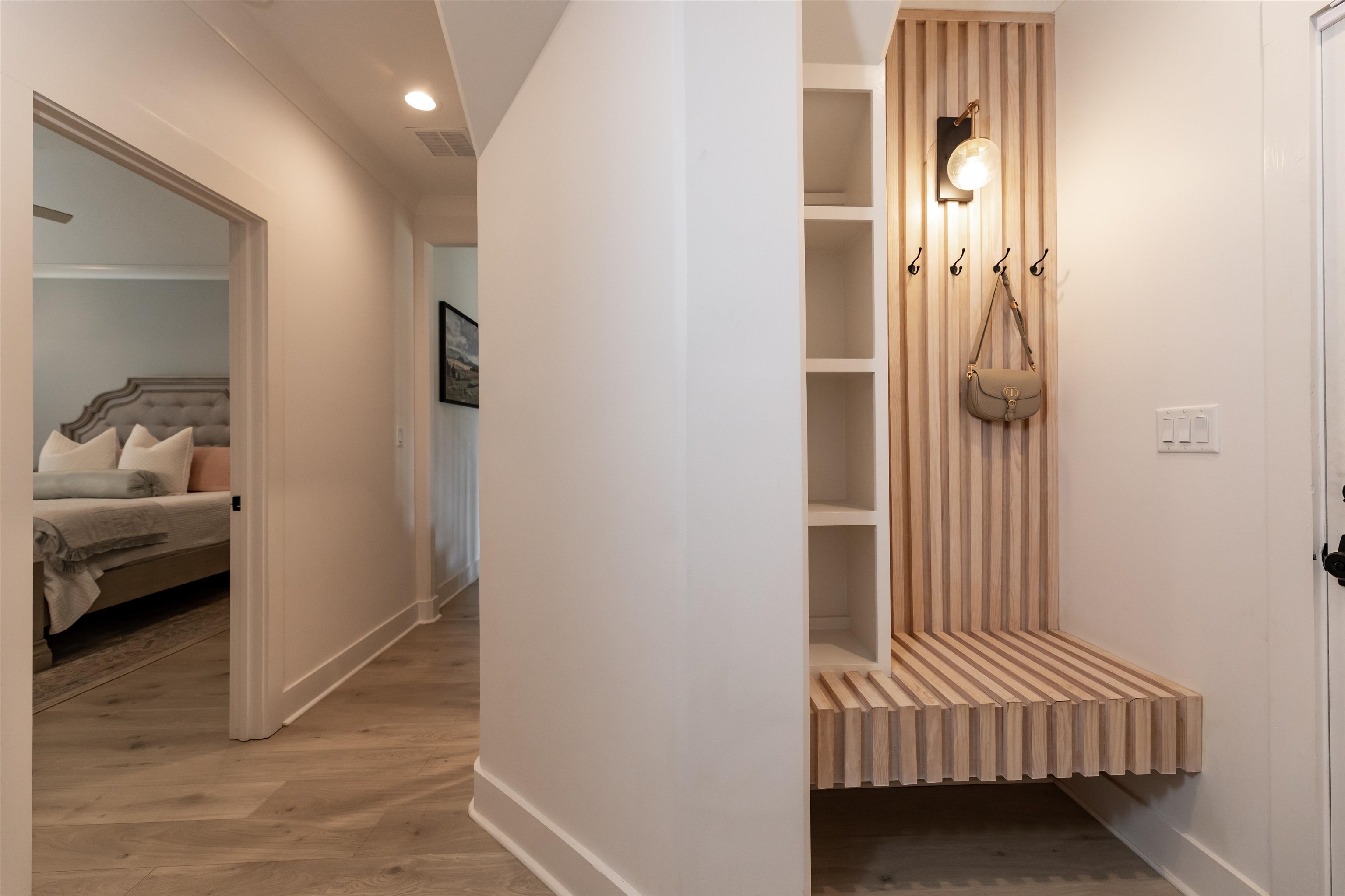 Interior space with ornamental molding, built in shelves, and hardwood / wood-style floors