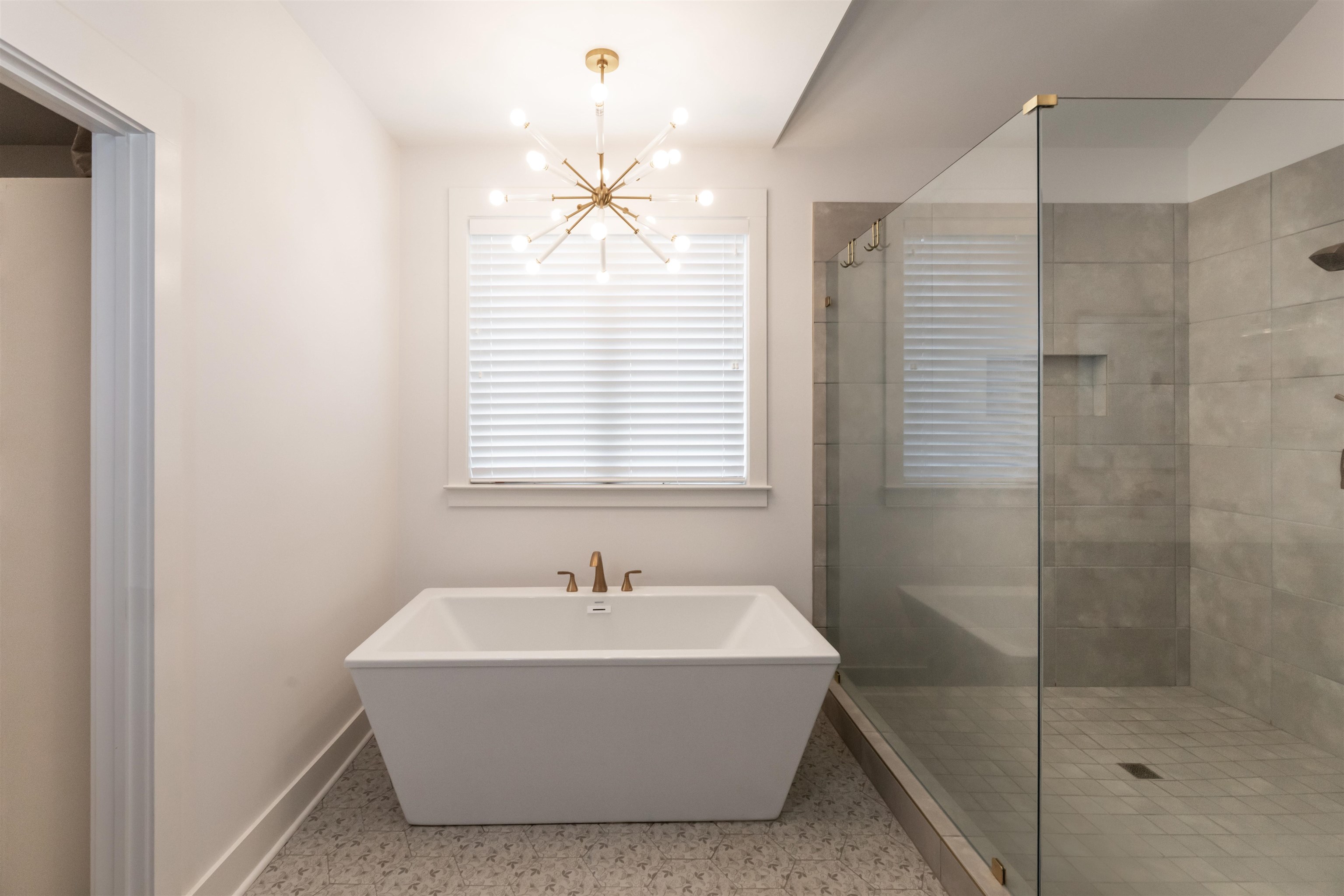 Bathroom featuring an inviting chandelier and separate shower and tub