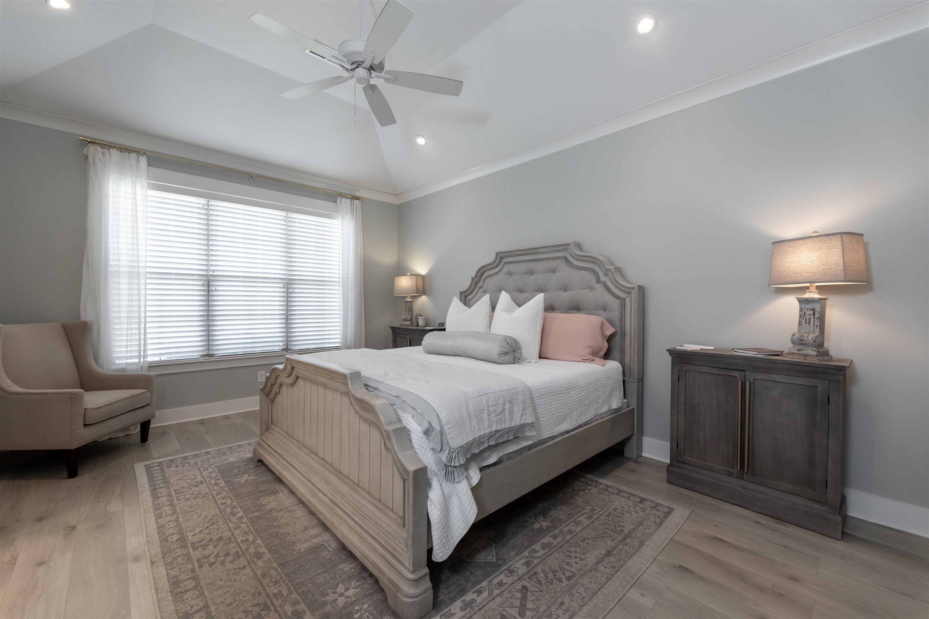 Bedroom featuring ornamental molding, wood-type flooring, ceiling fan, and vaulted ceiling