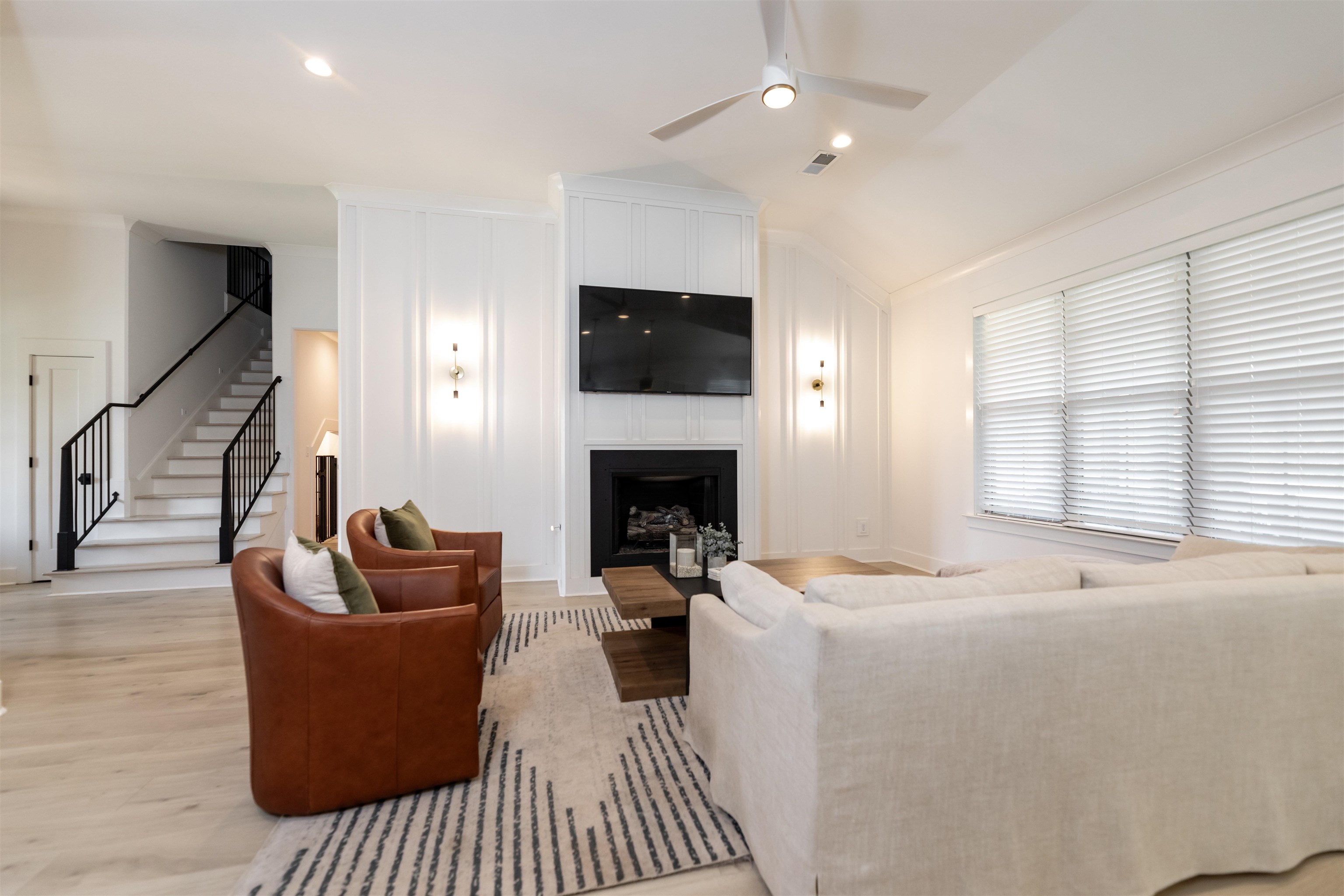 Living room featuring ceiling fan, light hardwood / wood-style flooring, and lofted ceiling