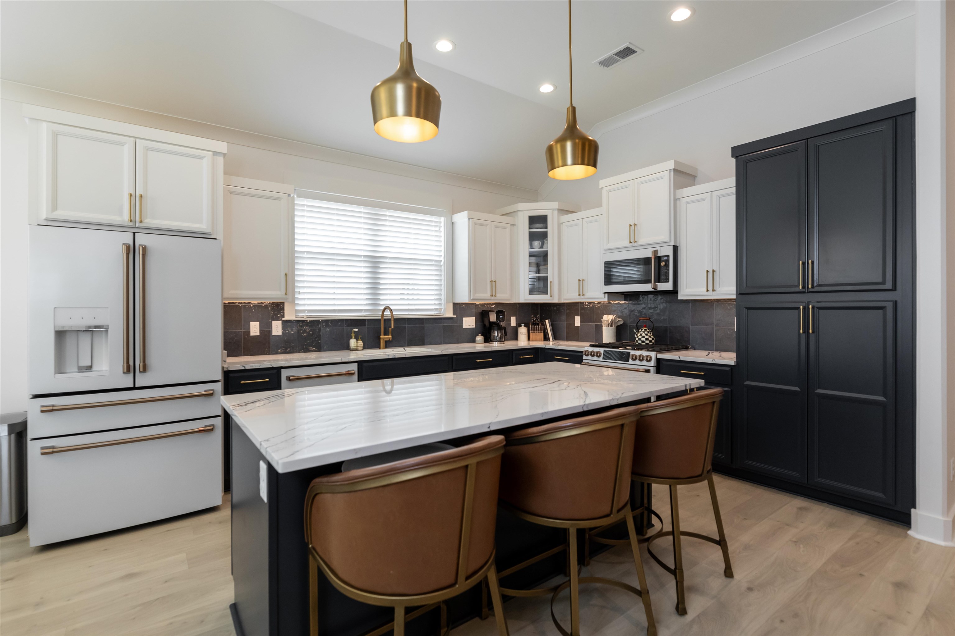 Kitchen with a center island, pendant lighting, light wood-type flooring, and stainless steel appliances