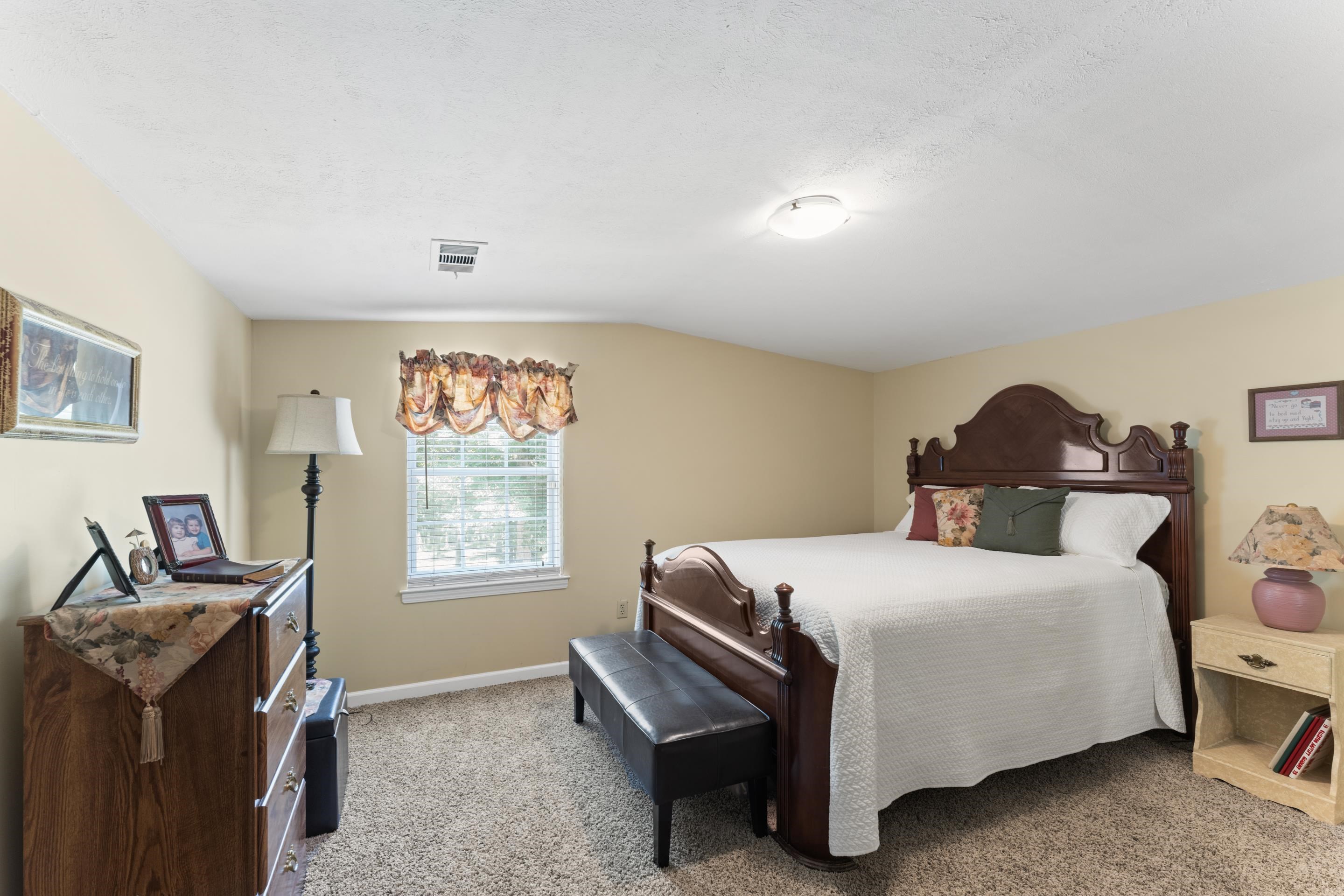 Carpeted bedroom with lofted ceiling