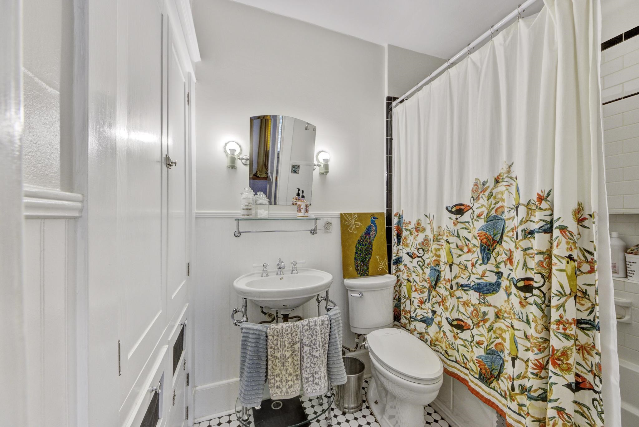 The primary bathroom features a new vanity, a wall of built-ins/storage with two hampers, and a tub/shower enclosure.