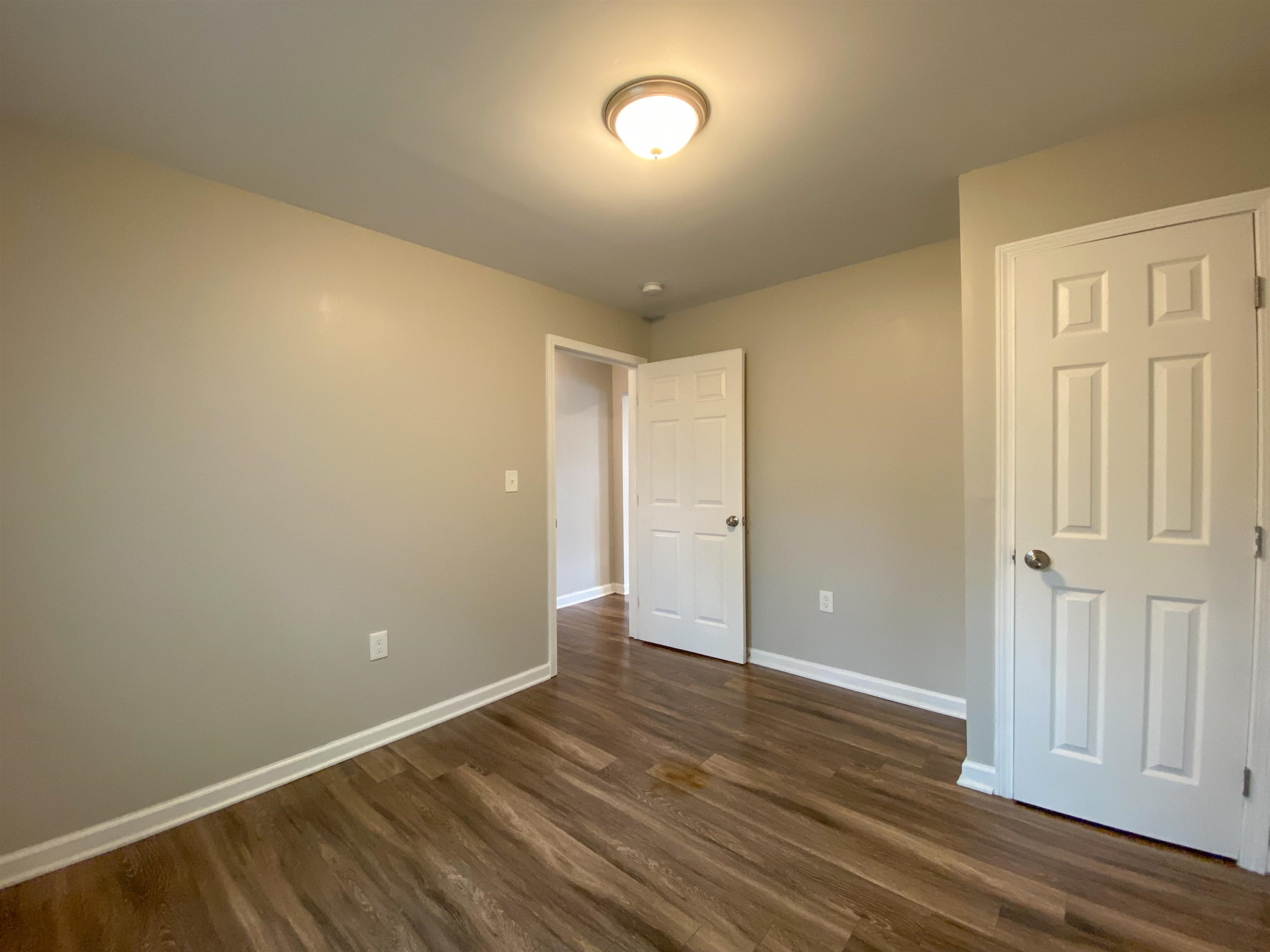 Unfurnished bedroom with dark hardwood / wood-style flooring