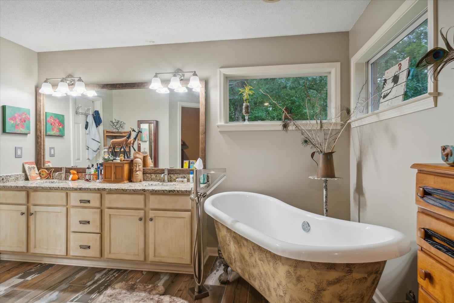 Bathroom with a healthy amount of sunlight, double sink vanity, and hardwood / wood-style flooring