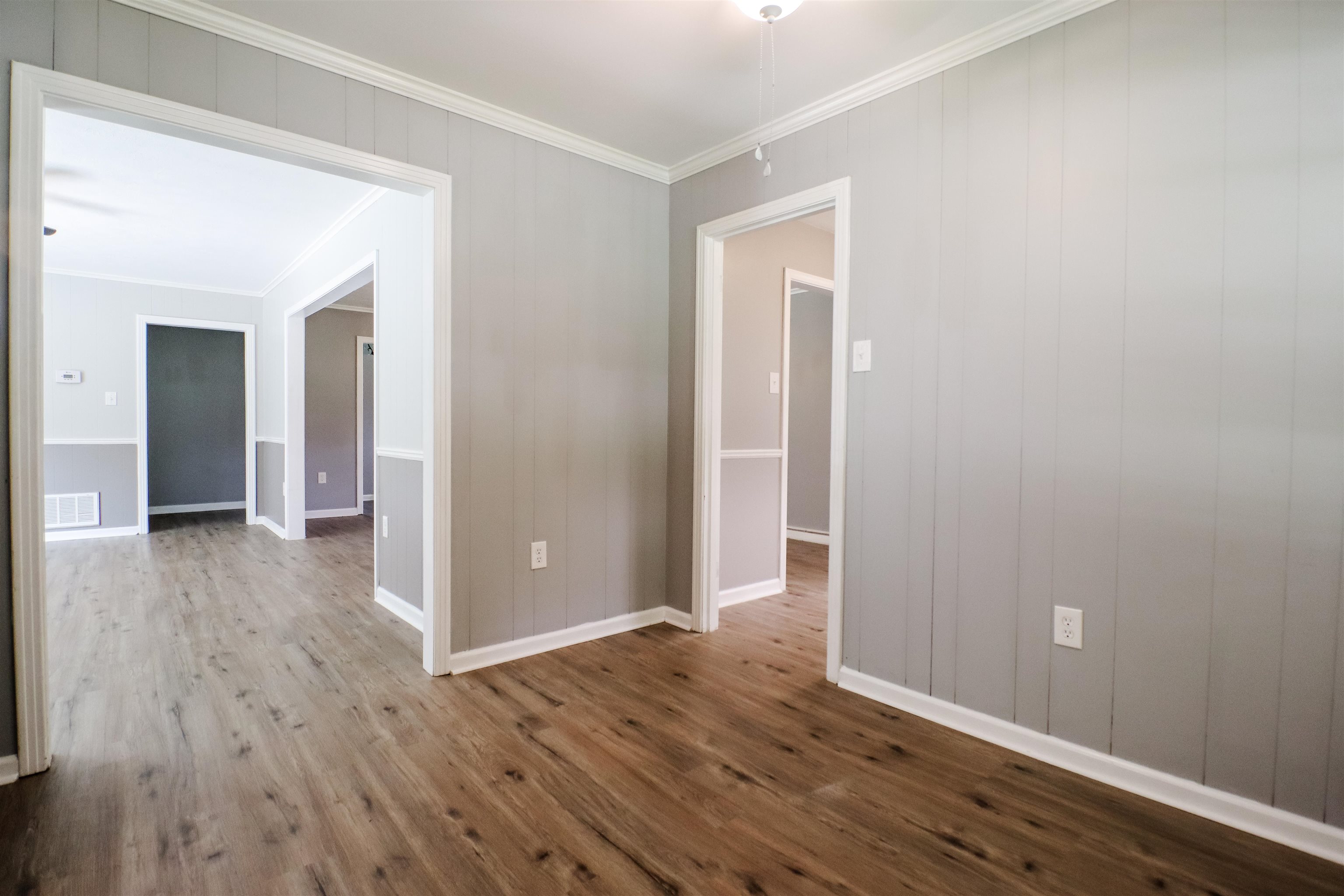 Empty room with wood-type flooring and crown molding