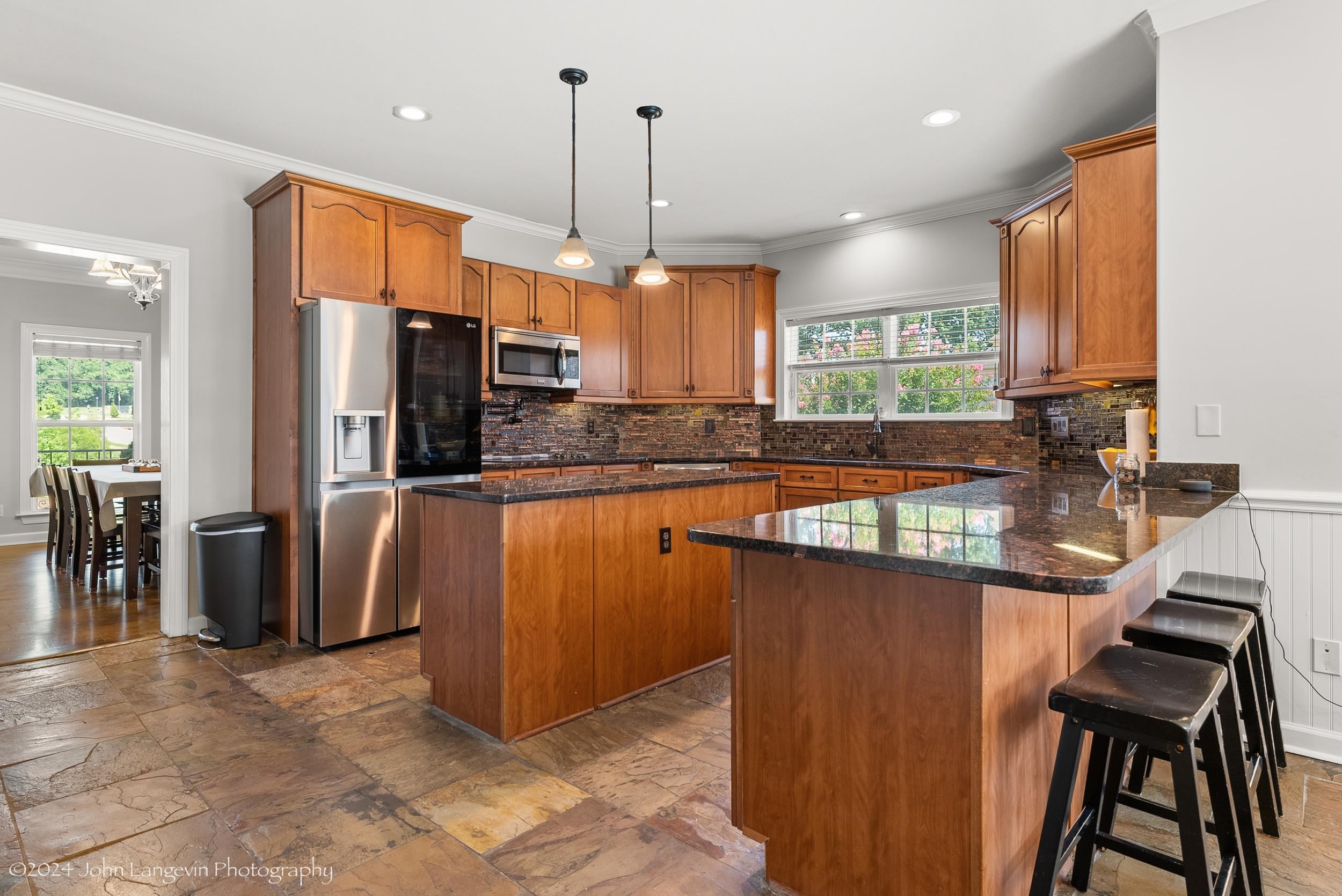 Kitchen with stainless steel appliances, backsplash, a center island, and pendant lighting