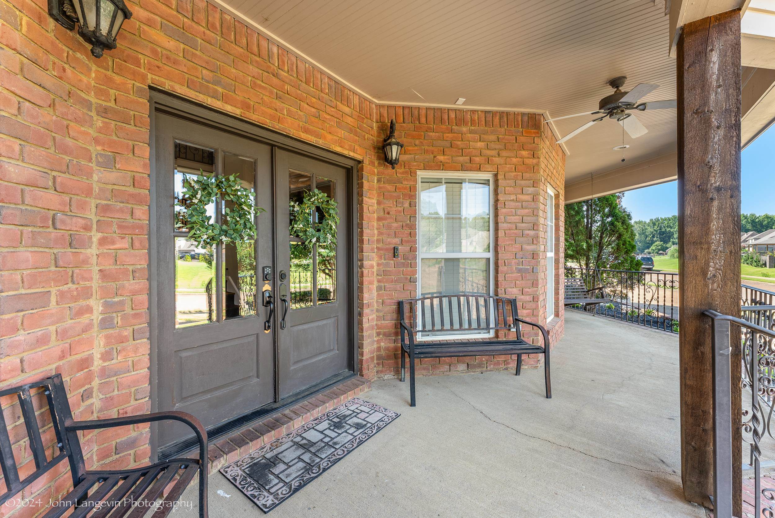 View of exterior entry featuring a porch and ceiling fan