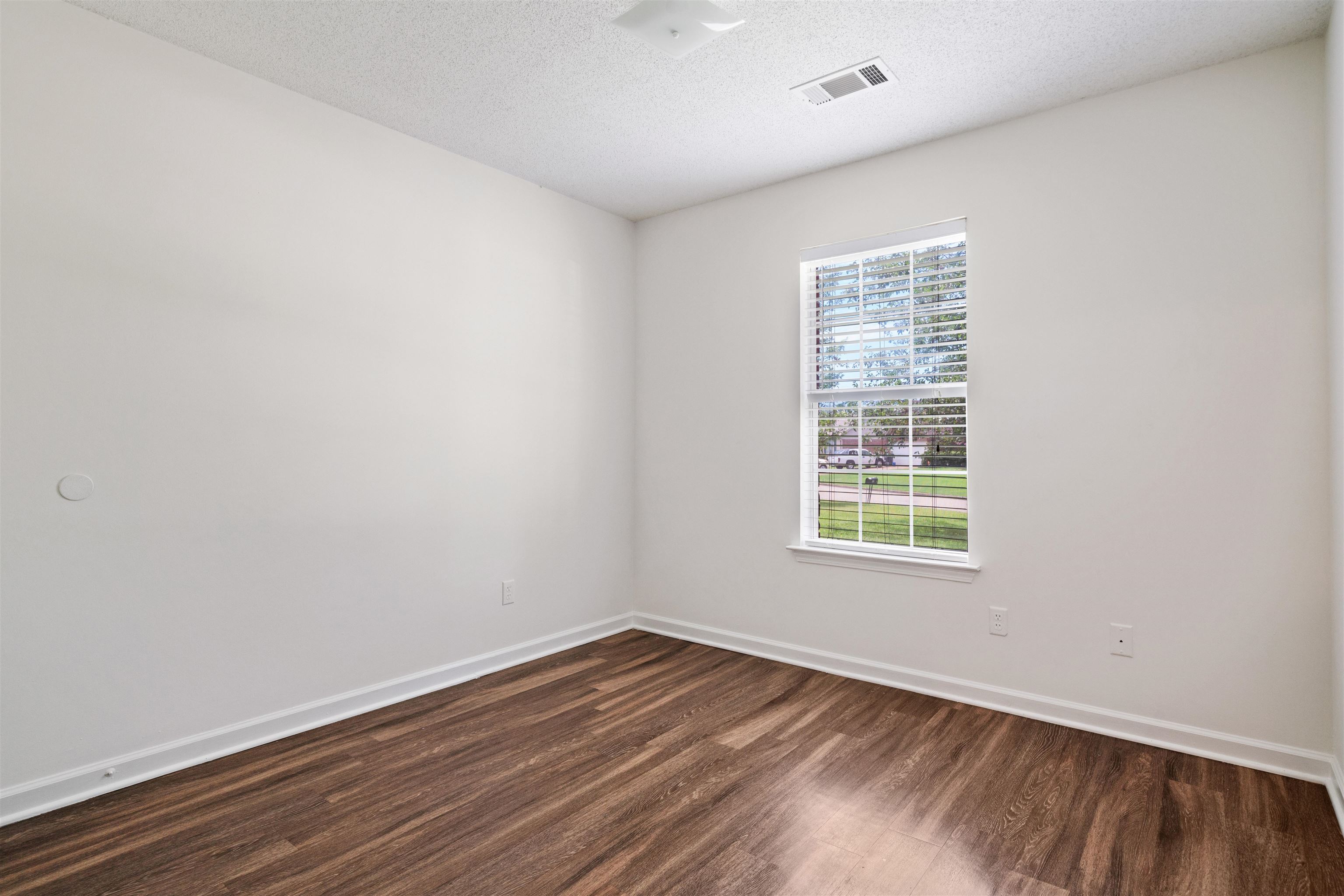 Bedroom 3 with a textured ceiling and hardwood / wood-style flooring